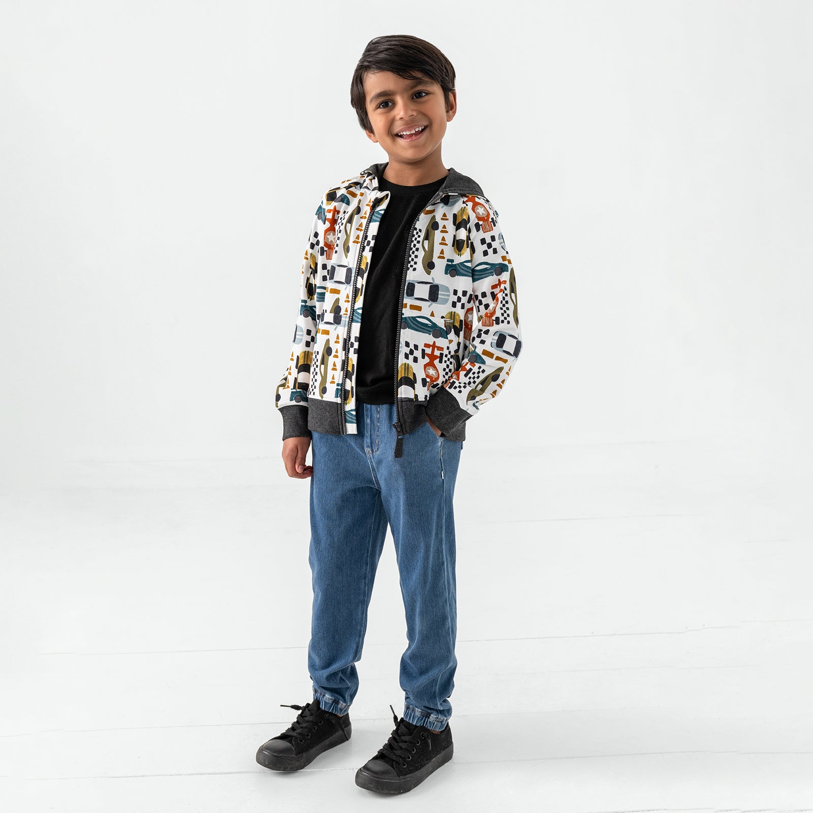 Standing child wearing the Fast Lane Zip Hoodie with denim joggers
