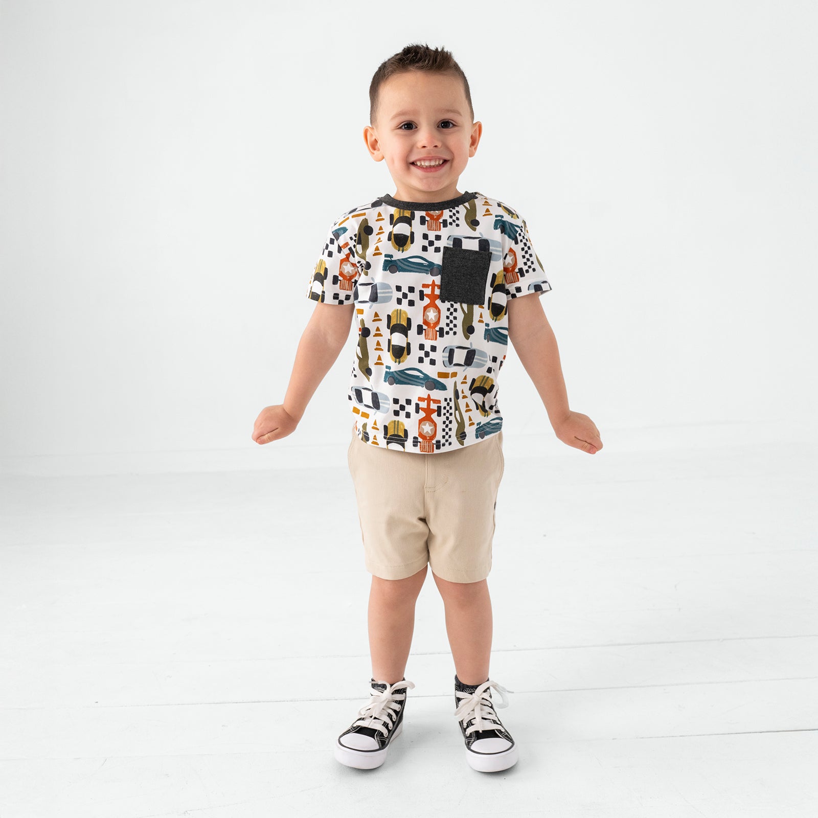 Standing boy wearing the Fast Lane Short Sleeve Relaxed Pocket Tee and light khaki chino shorts