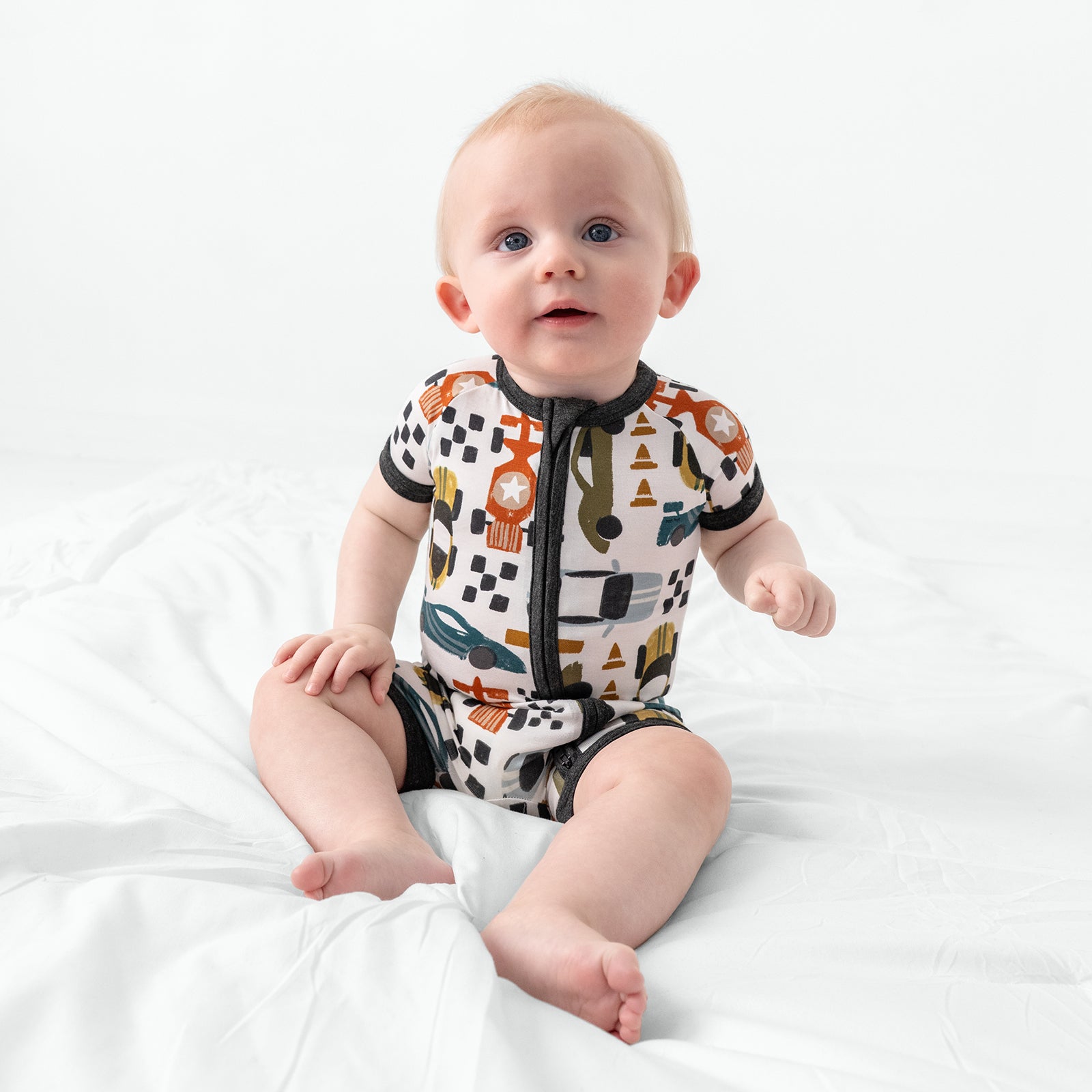 Sitting baby wearing the Fast Lane Shorty Bamboo Zippy