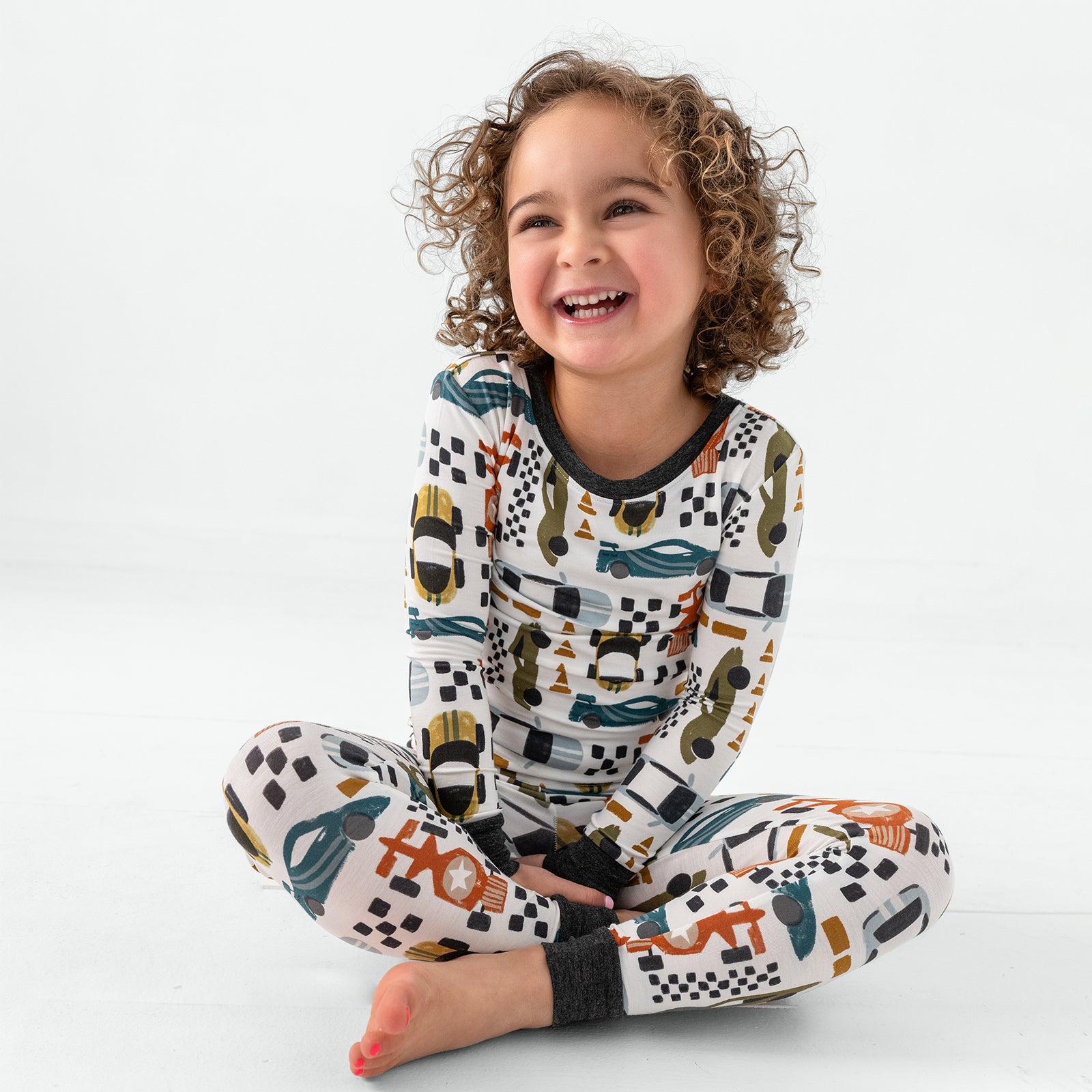 Sitting child wearing the Fast Lane Two-Piece Pajama Set