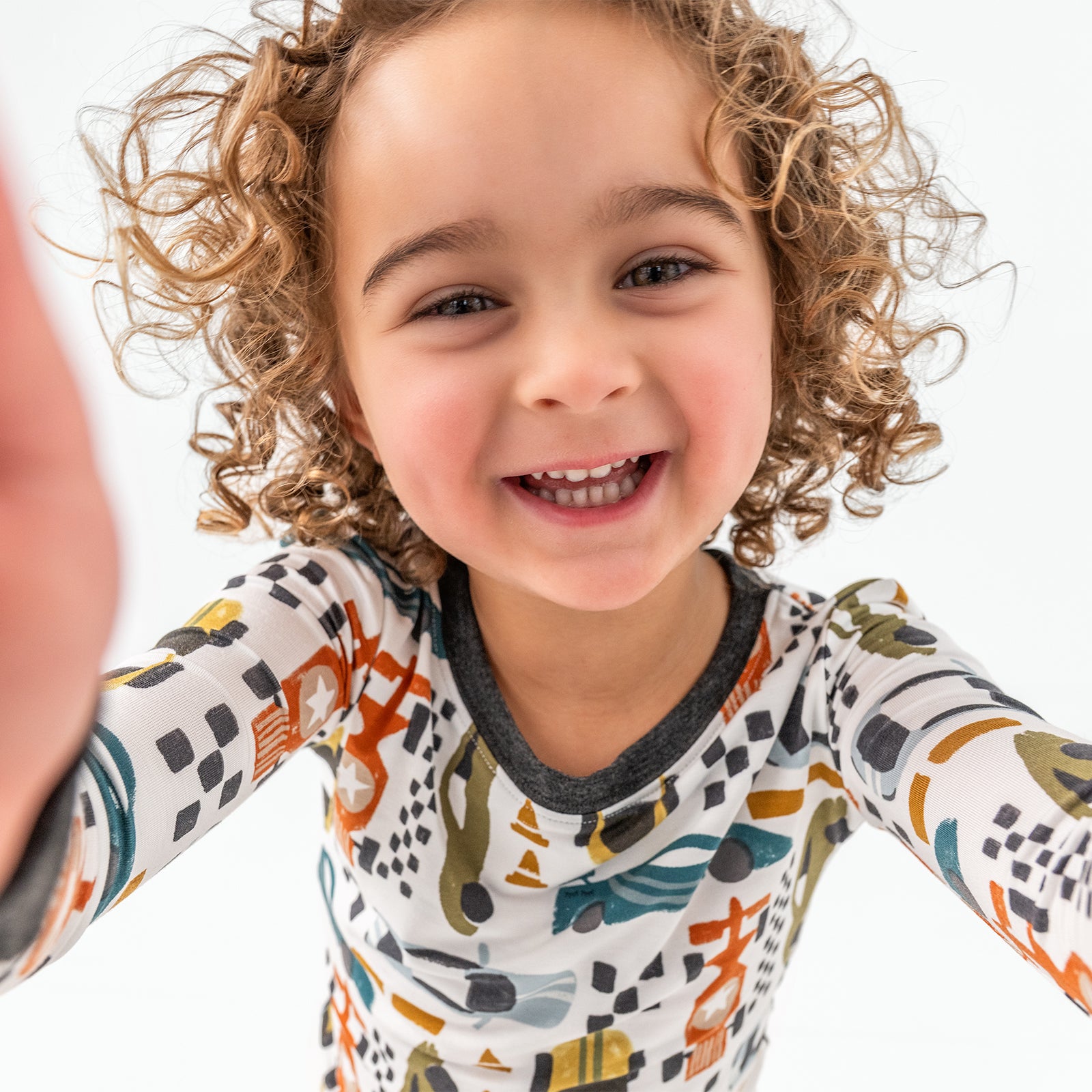 Child wearing the Fast Lane Two-Piece Pajama Set taking a selfie