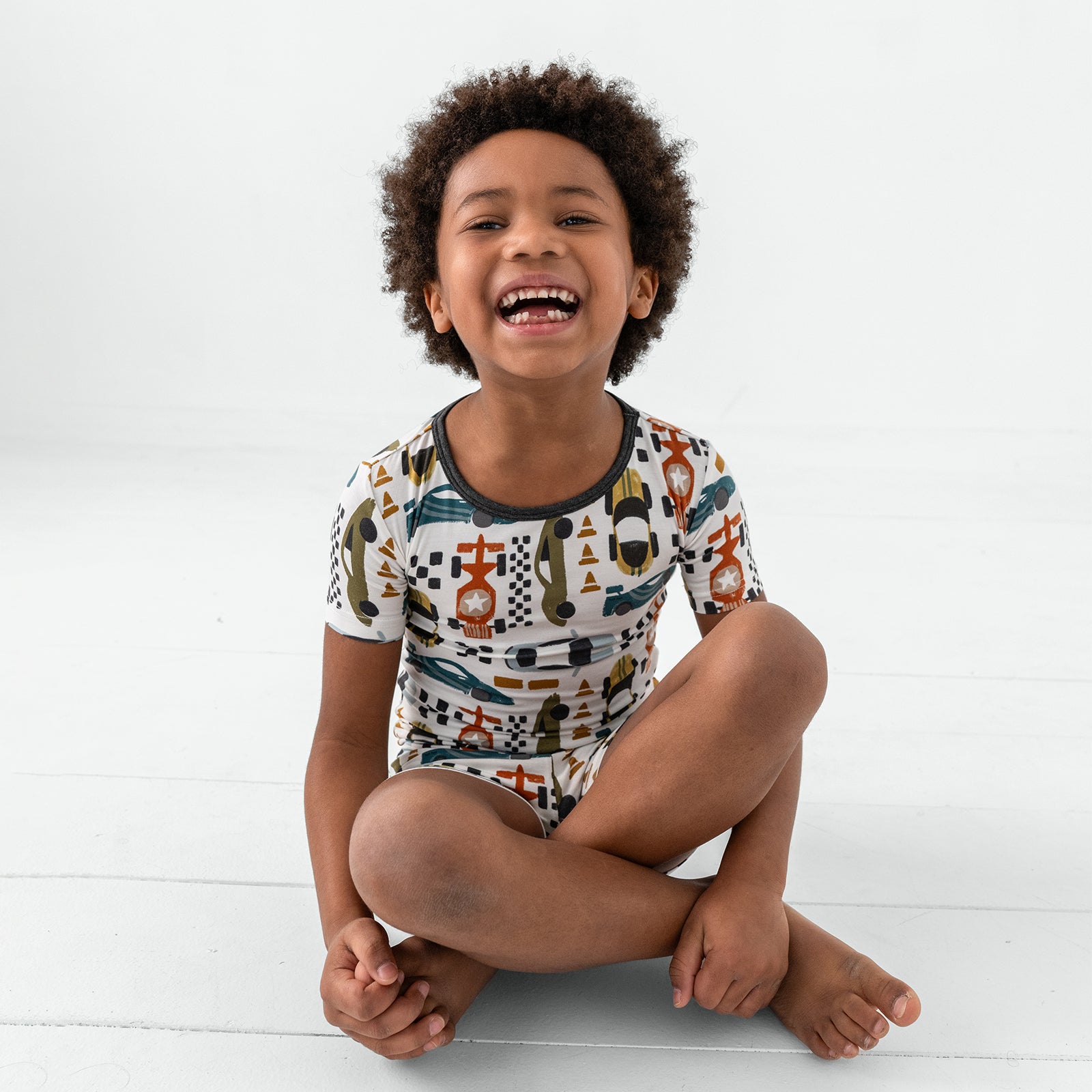 Sitting child wearing the Fast Lane Two-Piece Short Sleeve & Shorts Pajama Set