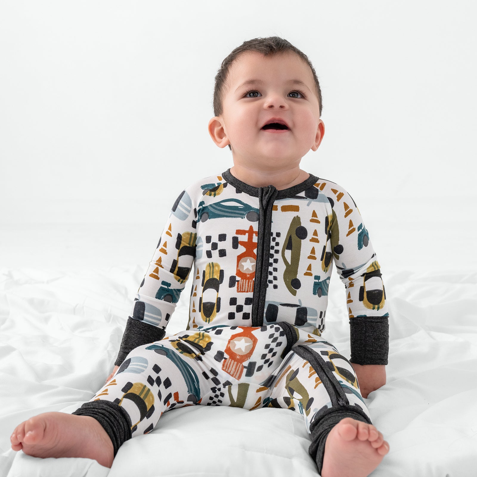Sitting child wearing the Fast Lane Bamboo Zipper Pajamas