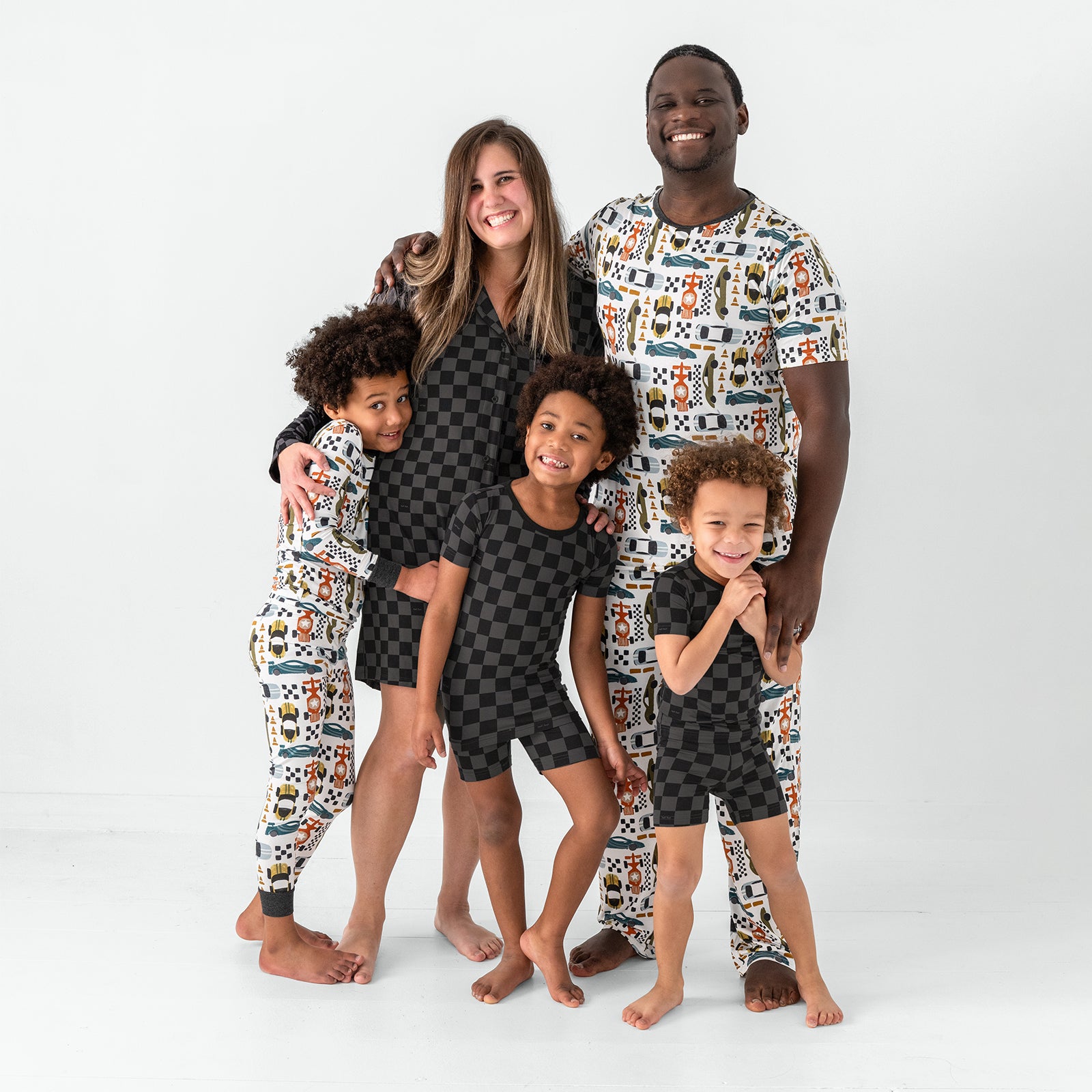 Family of five wearing a mix of Monochrome Checks and Fast Lane bamboo pajamas