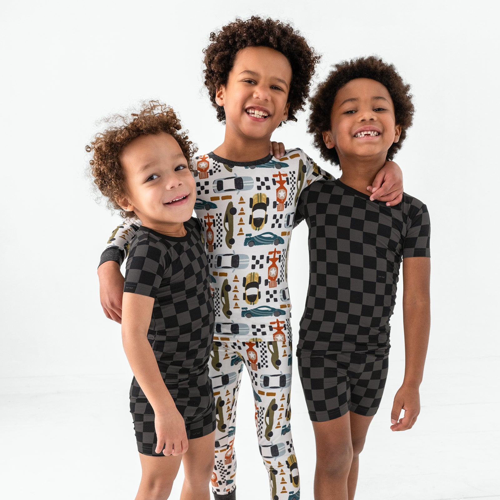 Three children wearing a mix of Fast Lane and Monochrome Checks pajamas
