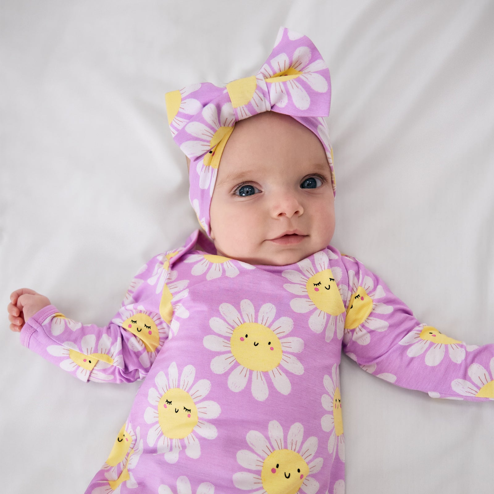 Alternate aerial view of child wearing the Flower Power Luxe Bow Headband with the matching infant gown