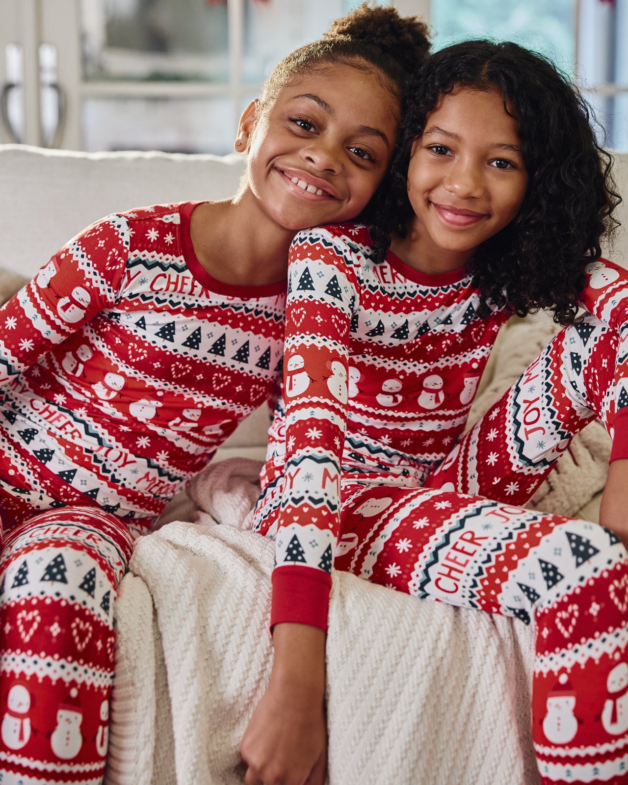 Two children wearing matching Festive Fair Isle Two-Piece Pajama Sets