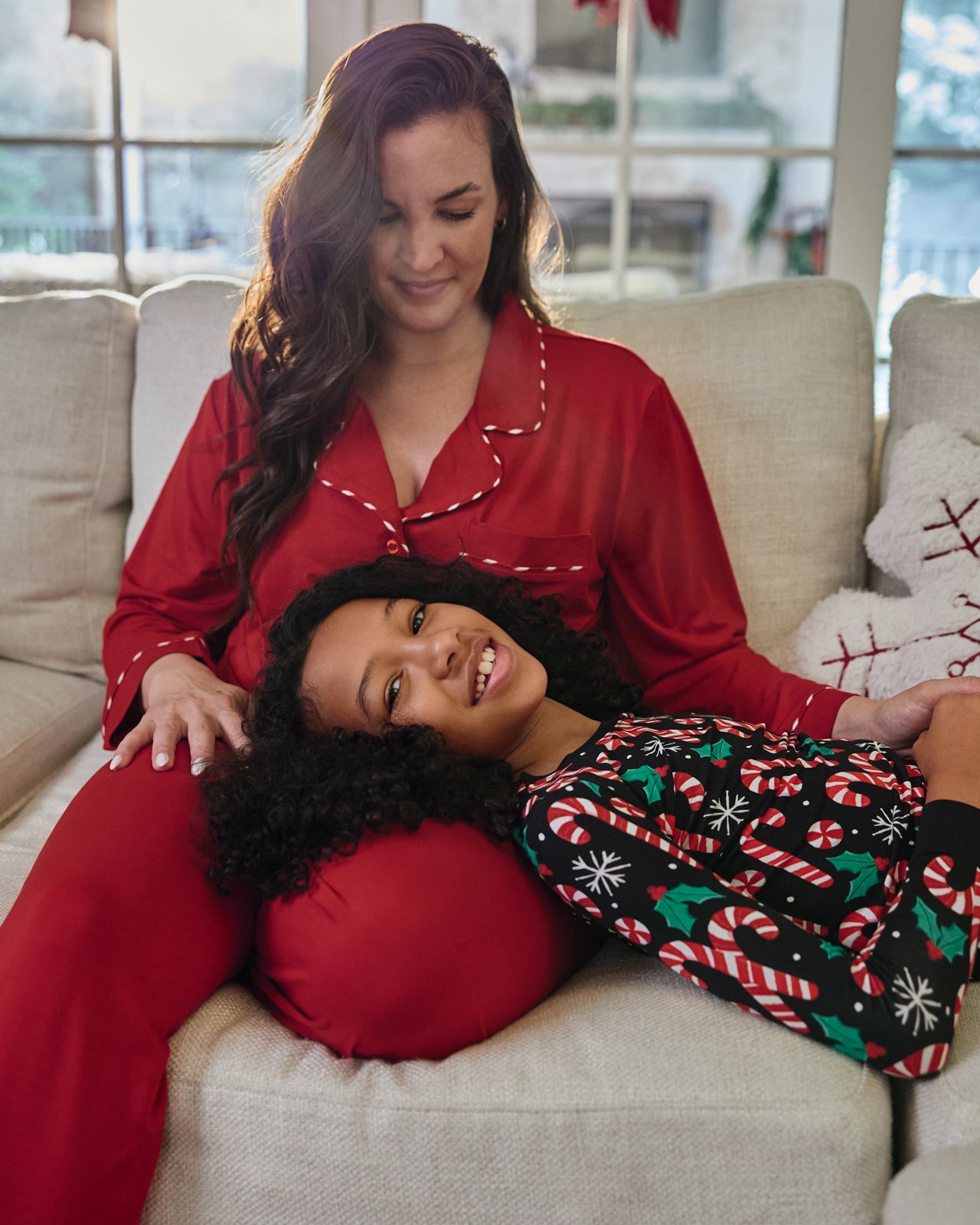 Woman sitting on a couch wearing the Holiday Red Women's Long Sleeve Pajama Set