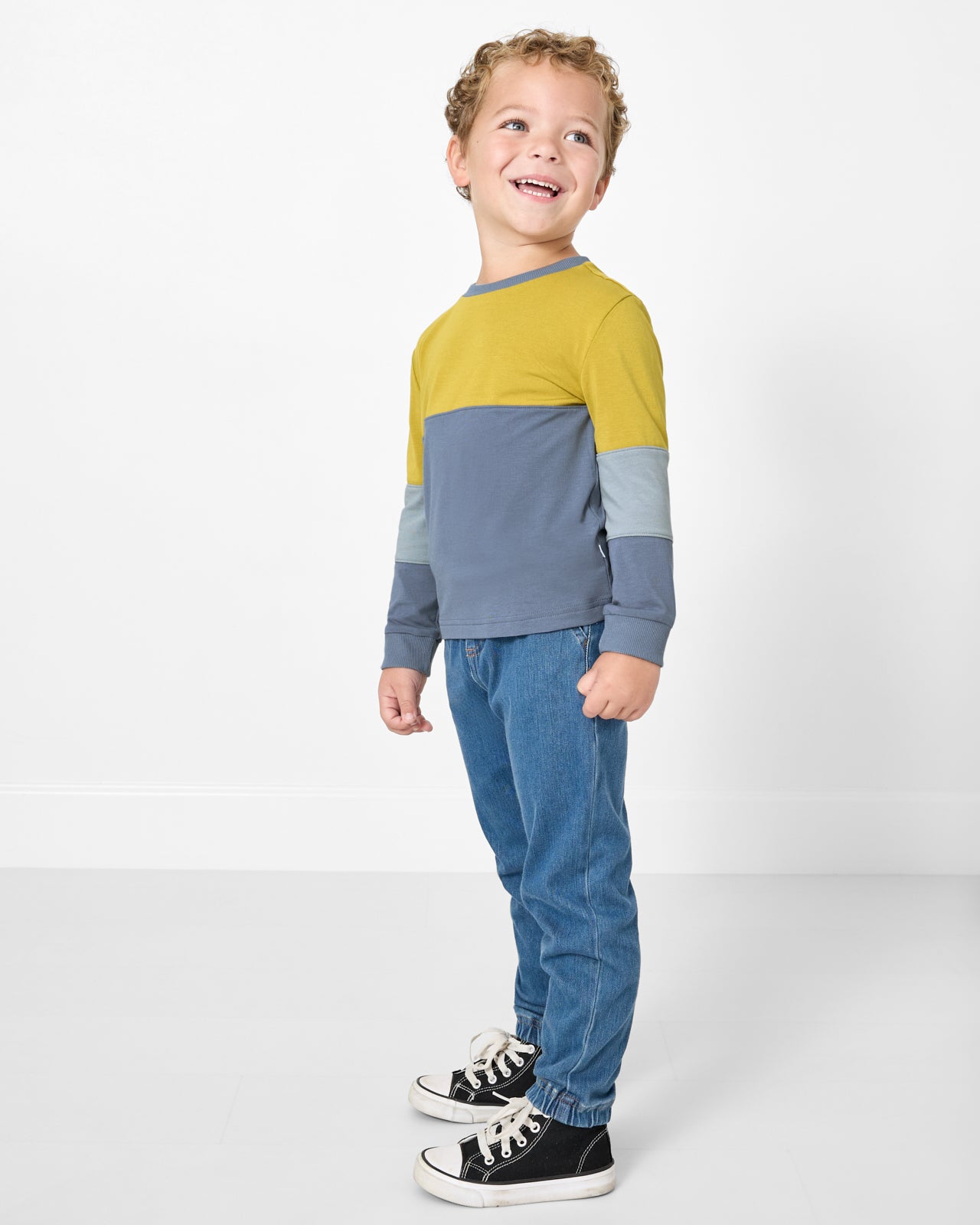 Boy wearing the Golden Moss Paneled Tee with denim pants