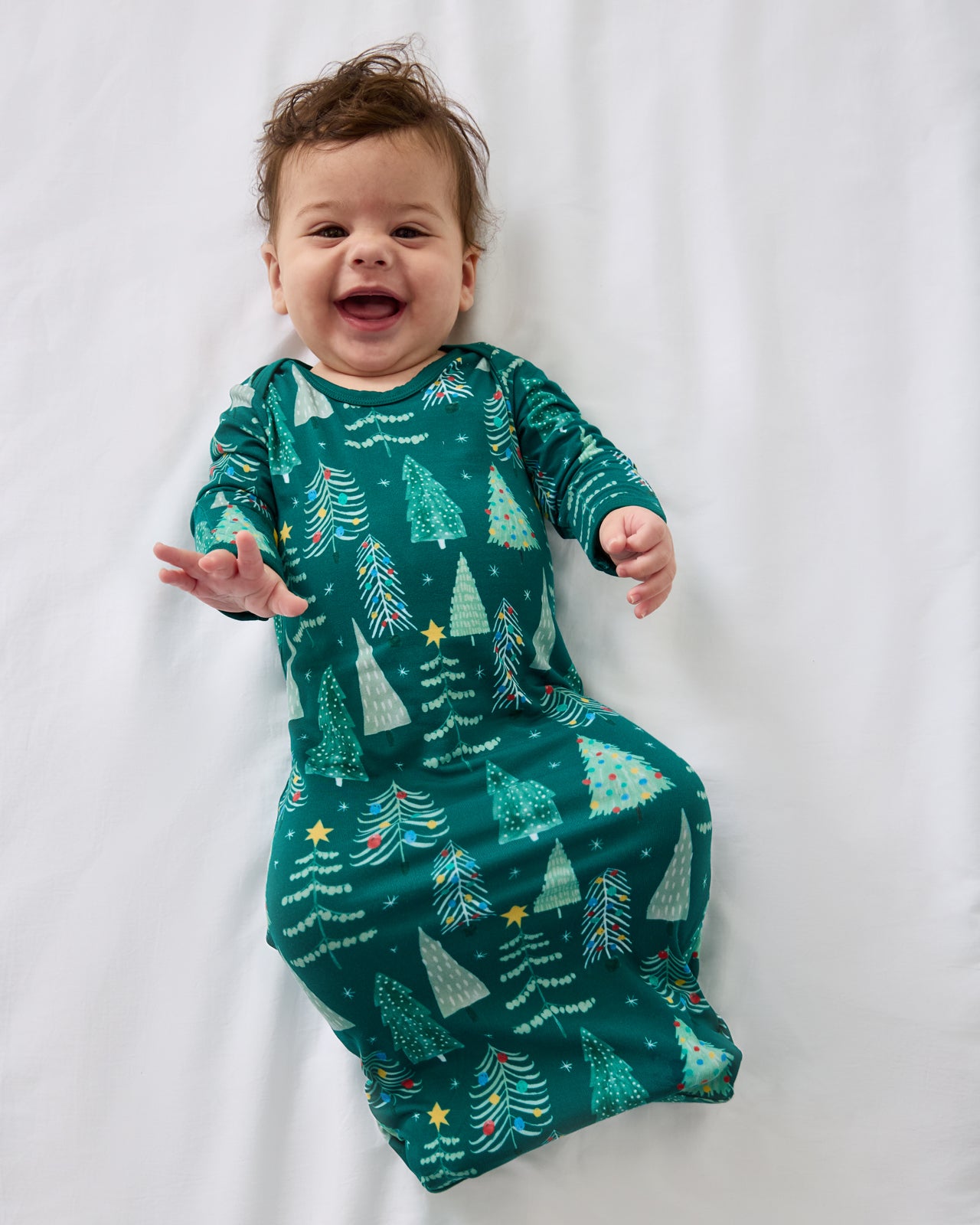 Alternate aerial view of baby wearing the Twinkling Trees Infant Gown