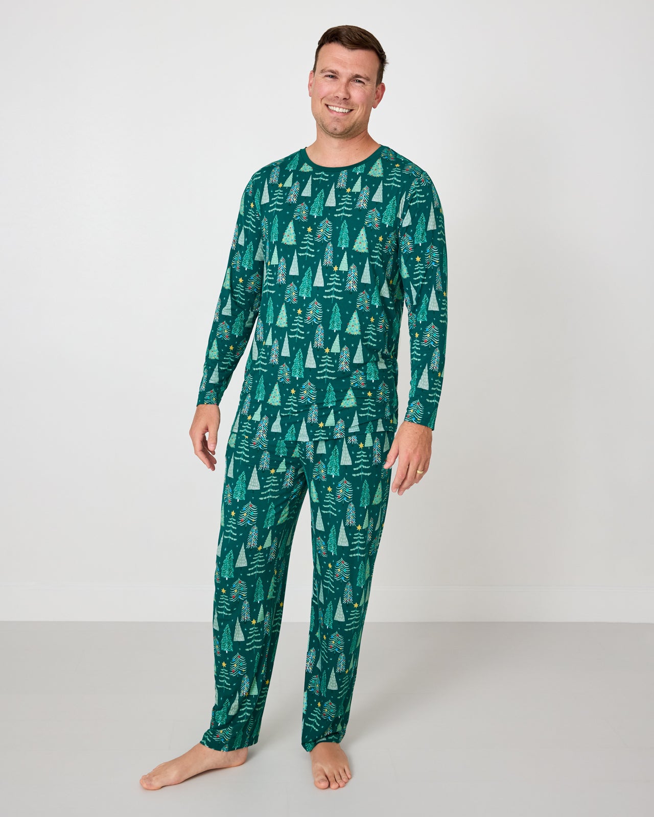 Man wearing the Twinkling Trees Men's Pajama Pants with a coordinating pajama top