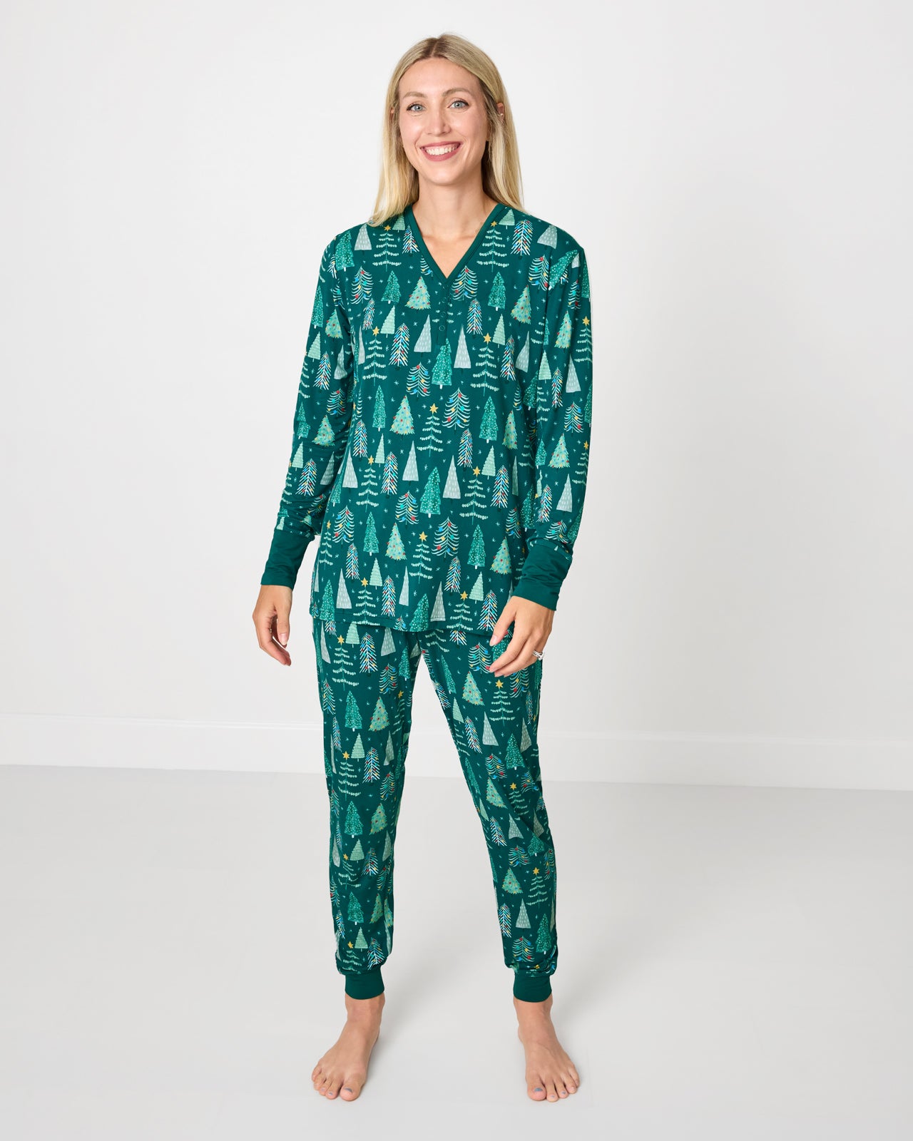 Woman wearing the Twinkling Trees Women's Long Sleeve Pajama Top with coordinating pajama pants