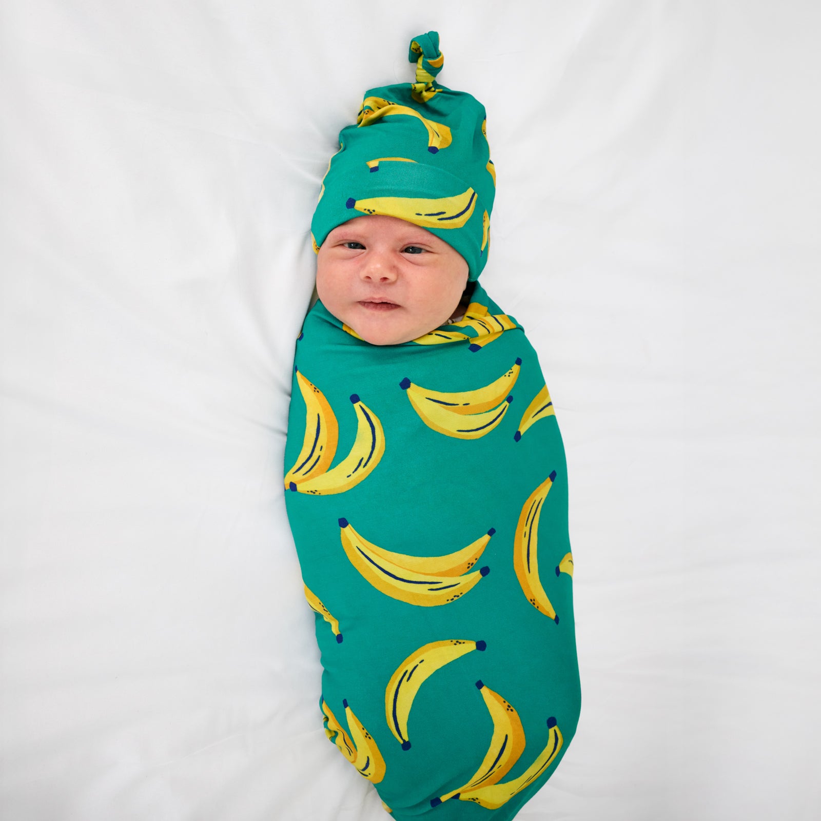 Aerial view of child wearing the Go Bananas Swaddle & Hat Set