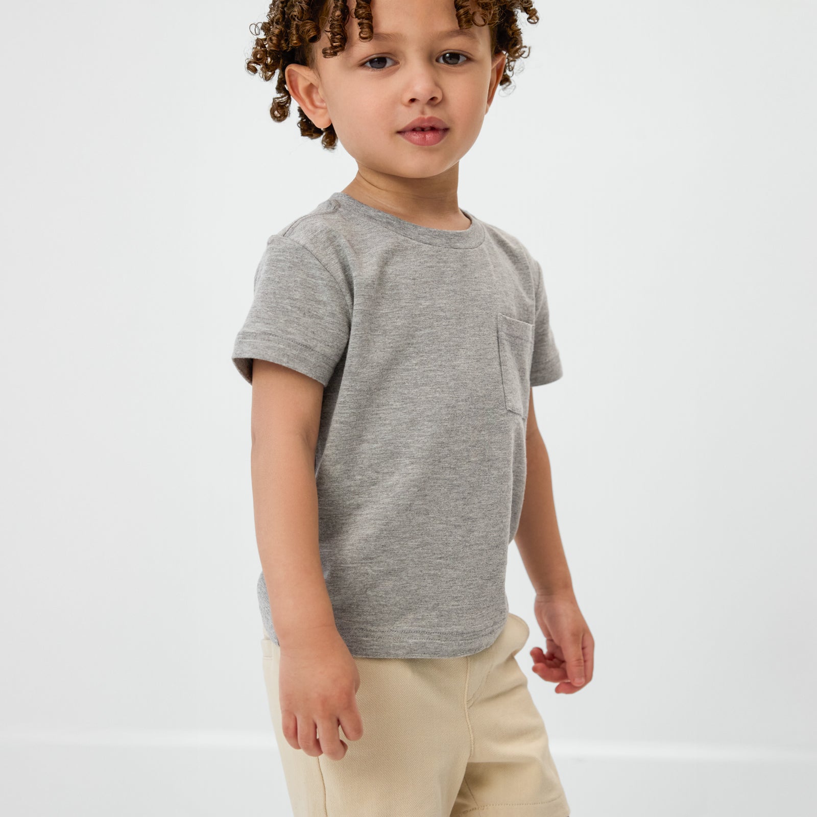 Close up of standing child wearing the Heather Gray Relaxed Pocket Tee
