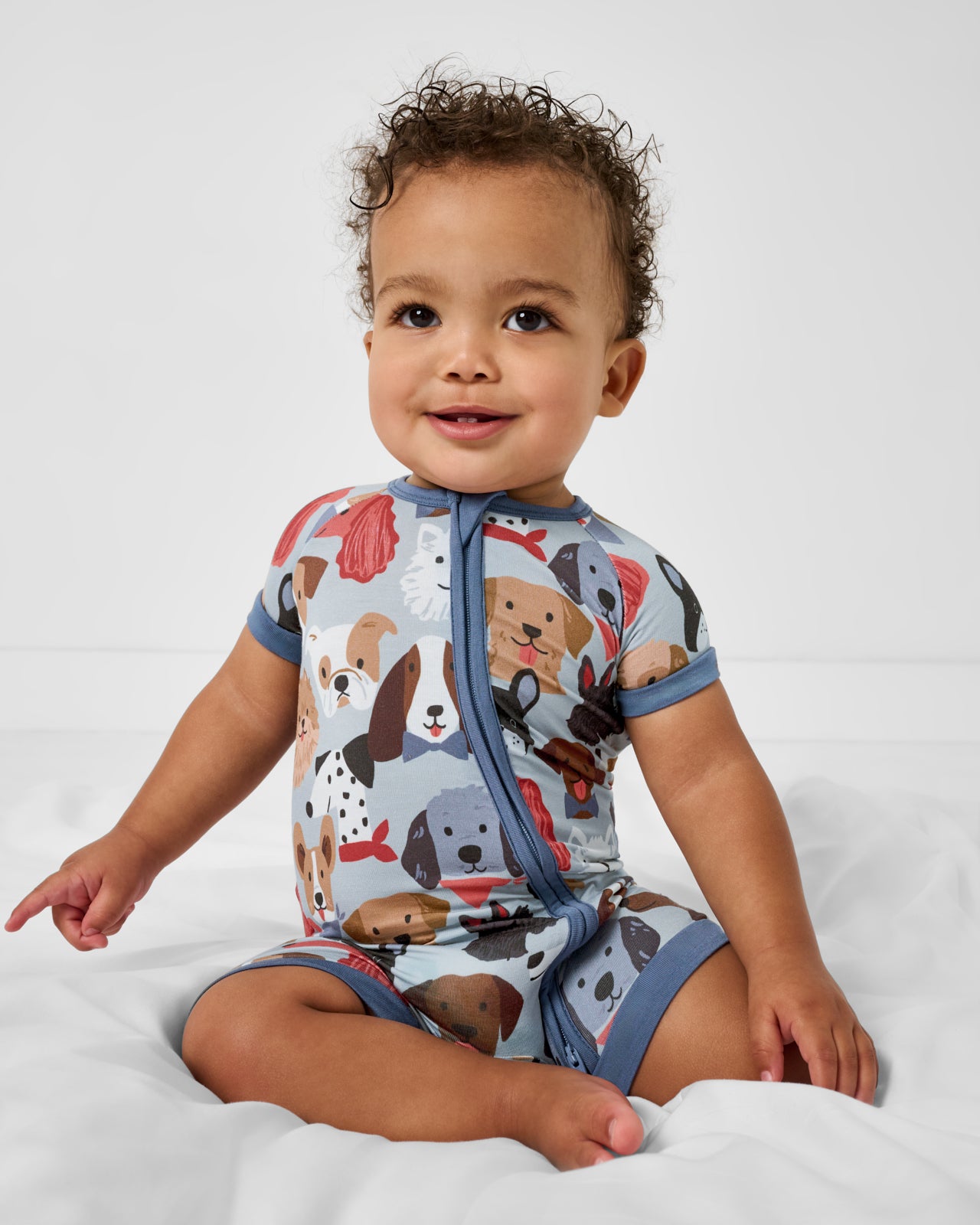 Sitting baby wearing the Gray Puppy Parade Shorty Zippy