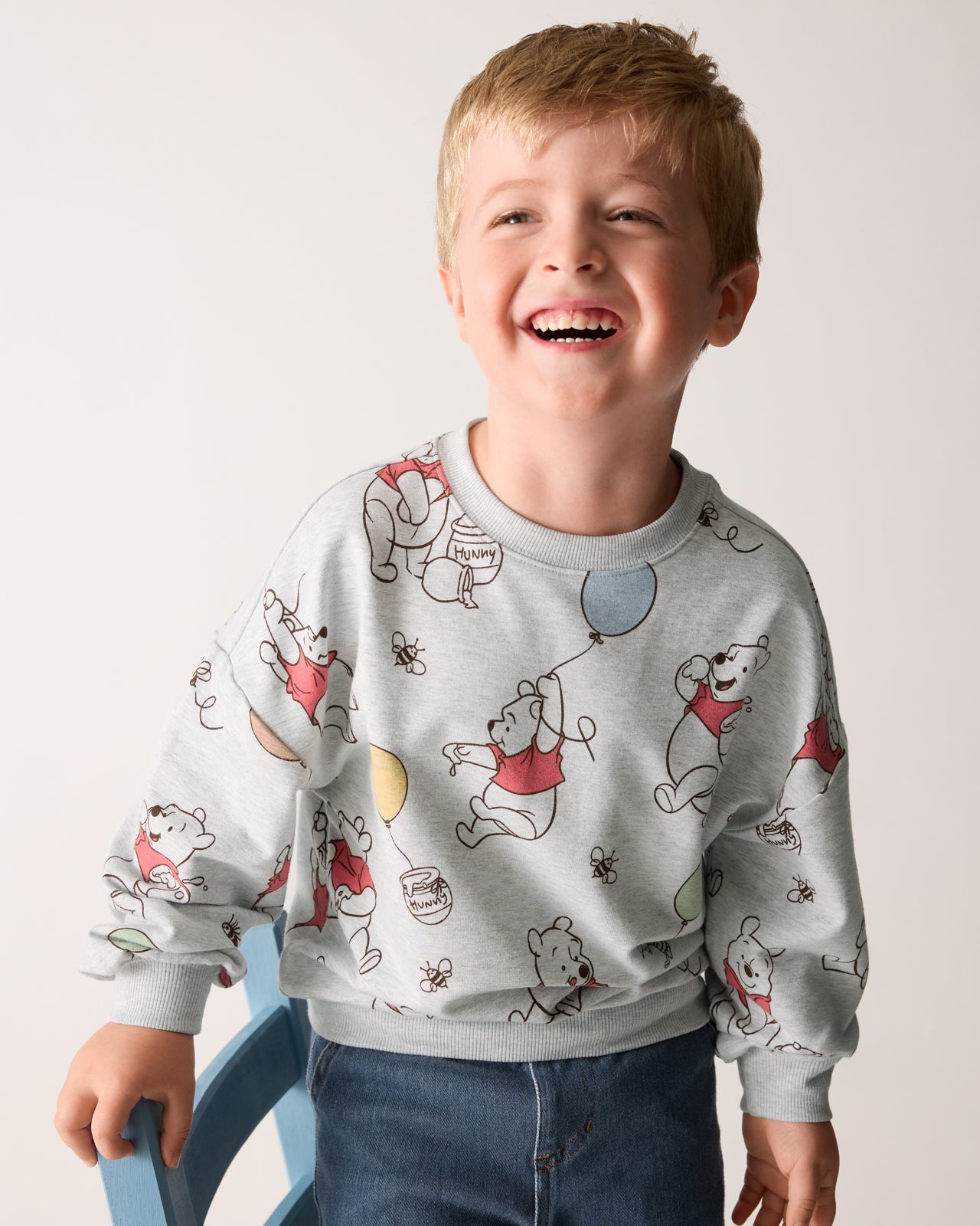 Boy wearing the Disney Up, Up and Away Drop Shoulder Crewneck with denim pants