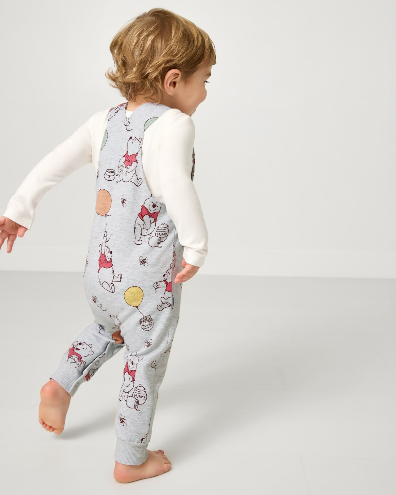 Back view of boy wearing the Disney Up, Up and Away Overall