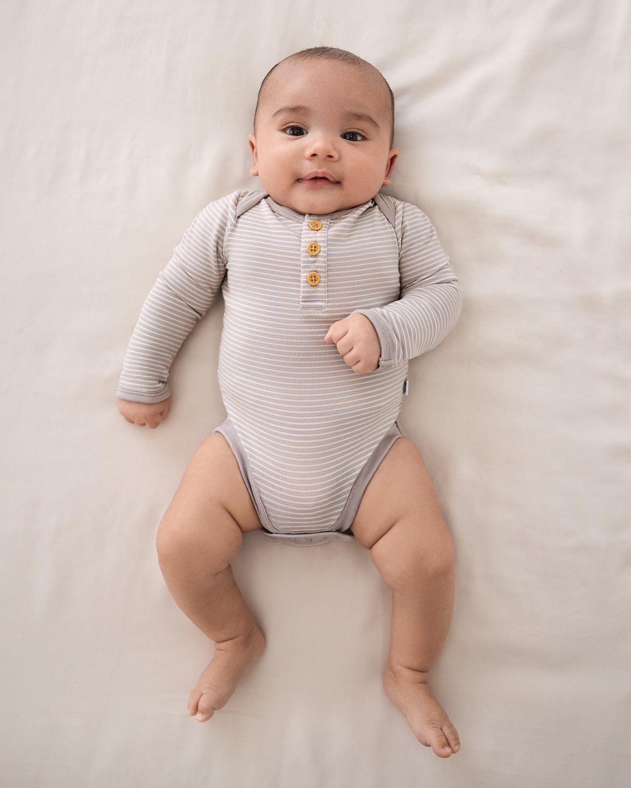 Overhead view of baby wearing the Dove Gray Stripe Henley Bodysuit