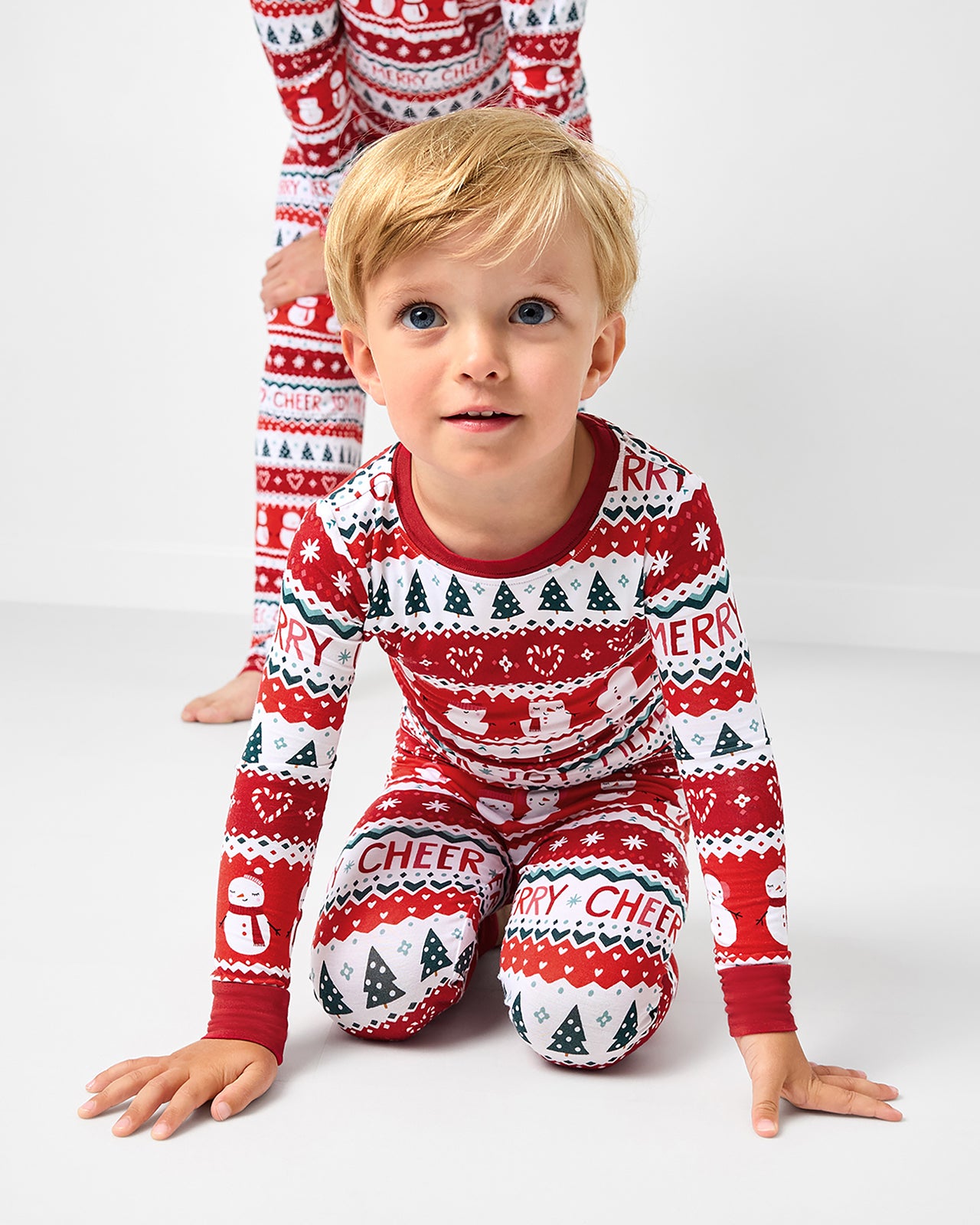 Sitting boy wearing the Festive Fair Isle Two-Piece Pajama Set