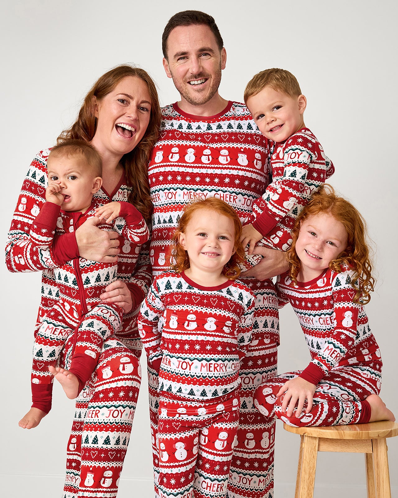 Family of six wearing matching Festive Fair Isle holiday pajamas