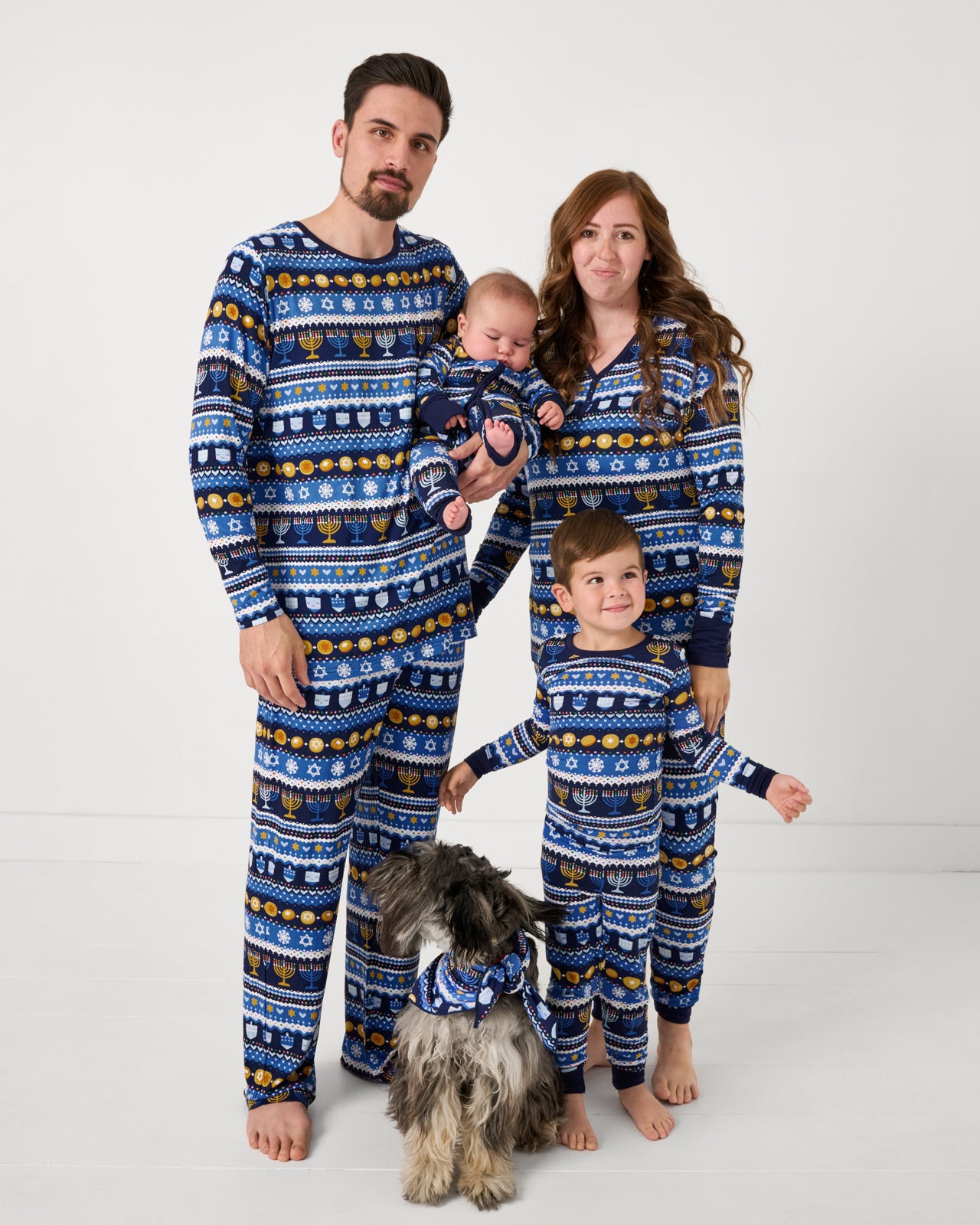 Family of four and their dog wearing matching Hanukkah Fair Isle pajamas