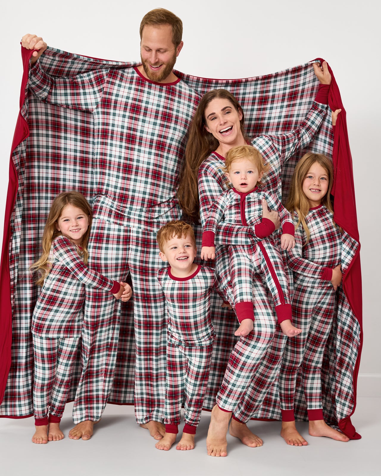 Family of 6 wearing matching Holly Plaid christmas pajamas