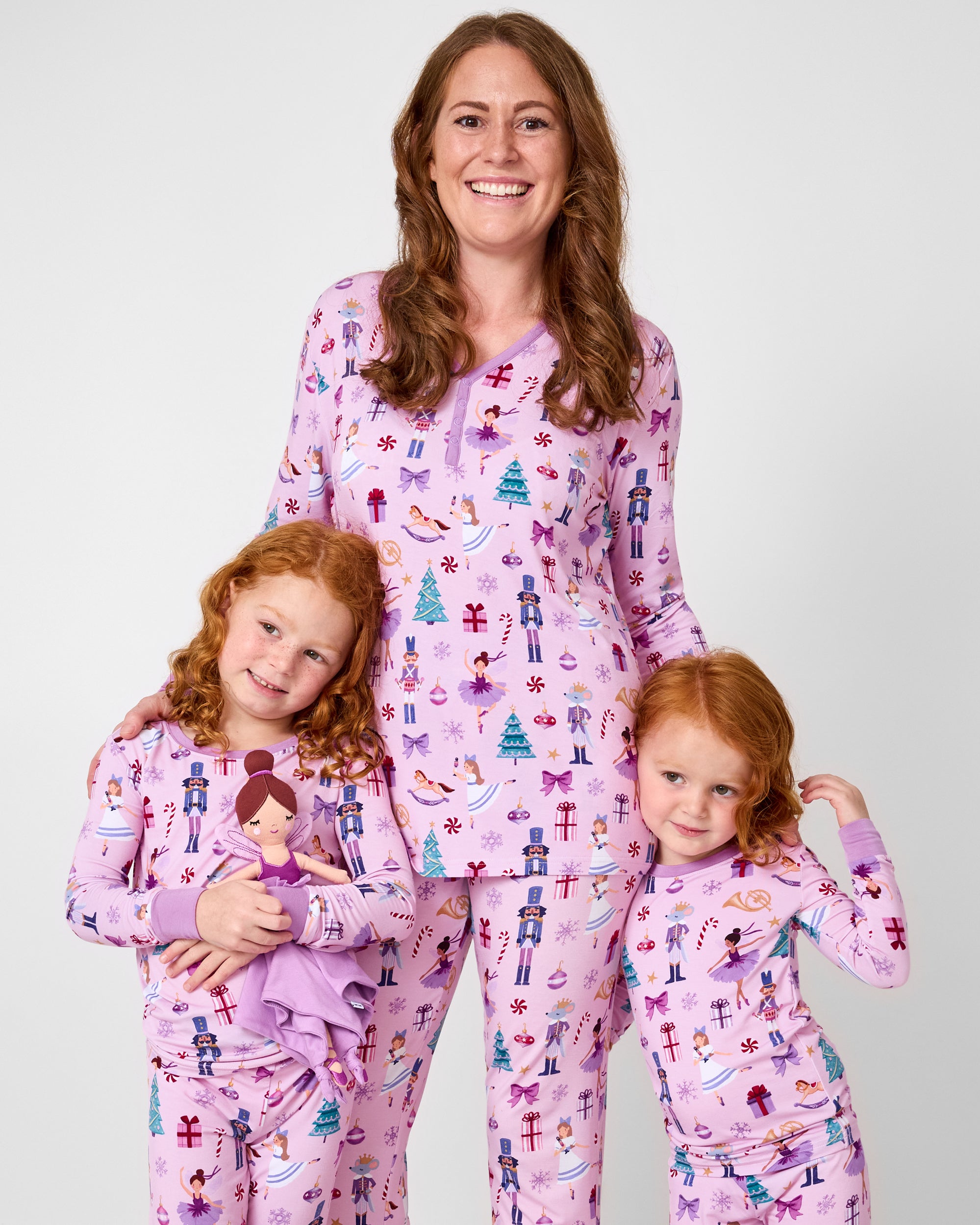 Family of three wearing matching Nutcracker Ballet holiday pajamas