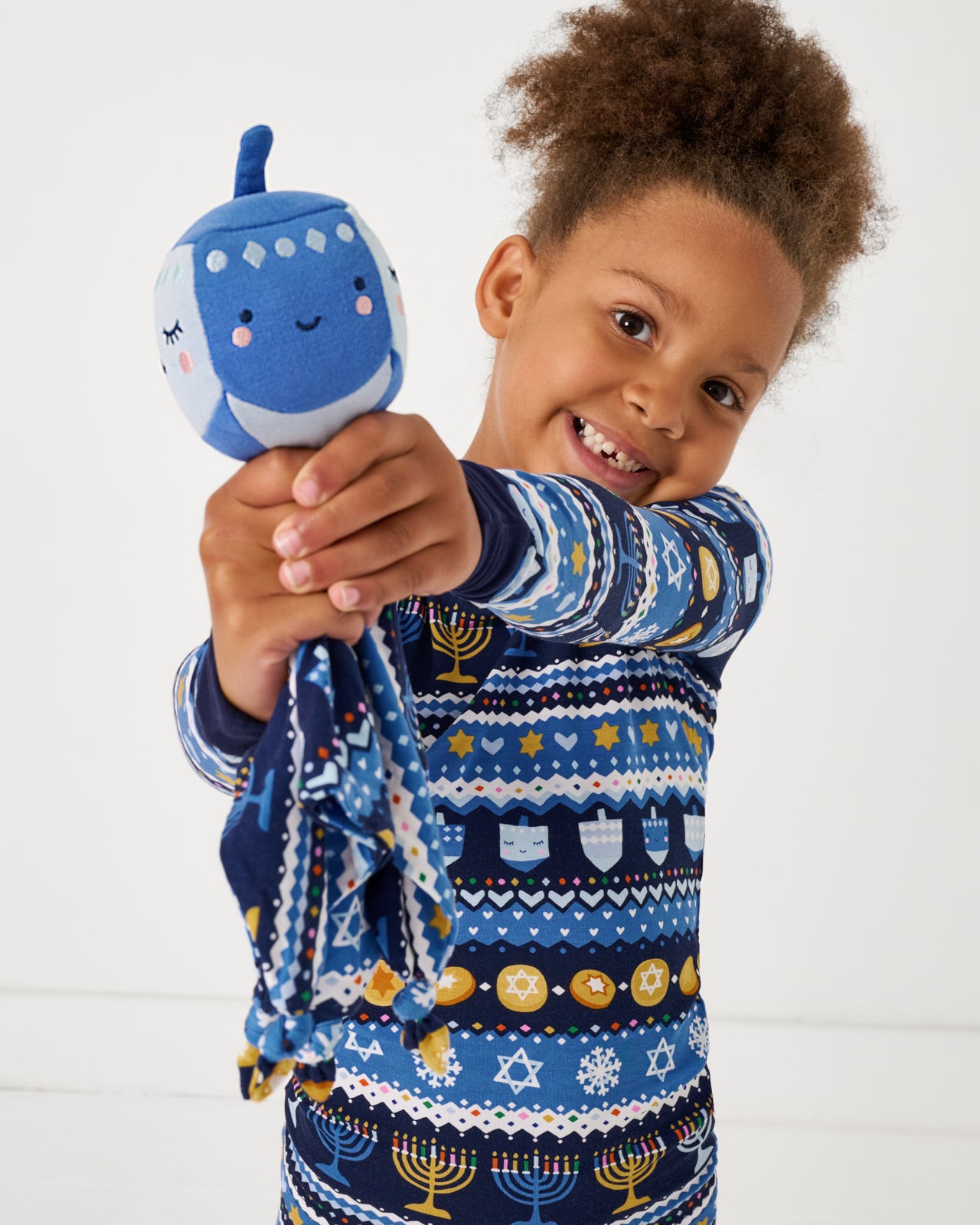 Girl holding up the Danny the Dreidel Sleepyhead Lovey