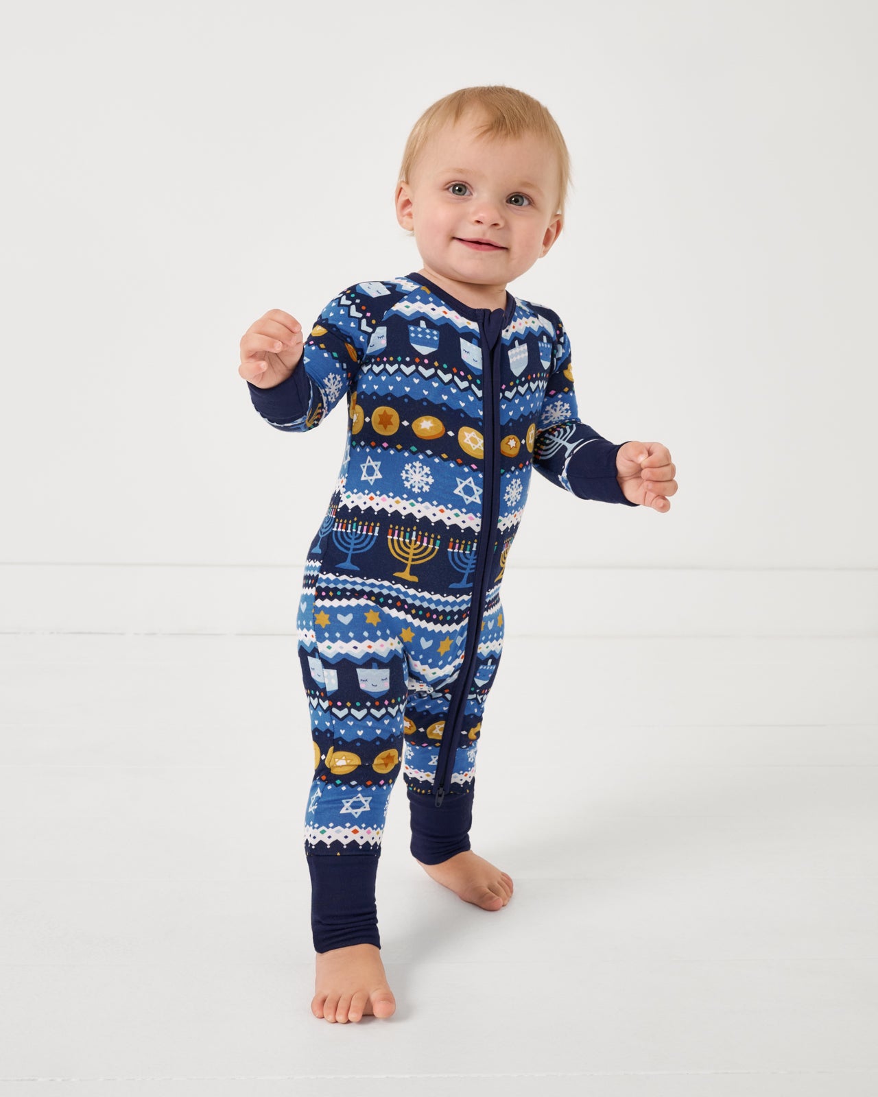 Standing toddler wearing the Hanukkah Fair Isle Zippy