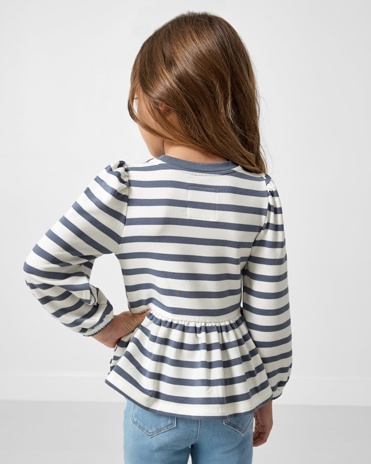 Back view of girl wearing the Hazy Blue Stripe Puff Sleeve Peplum Top