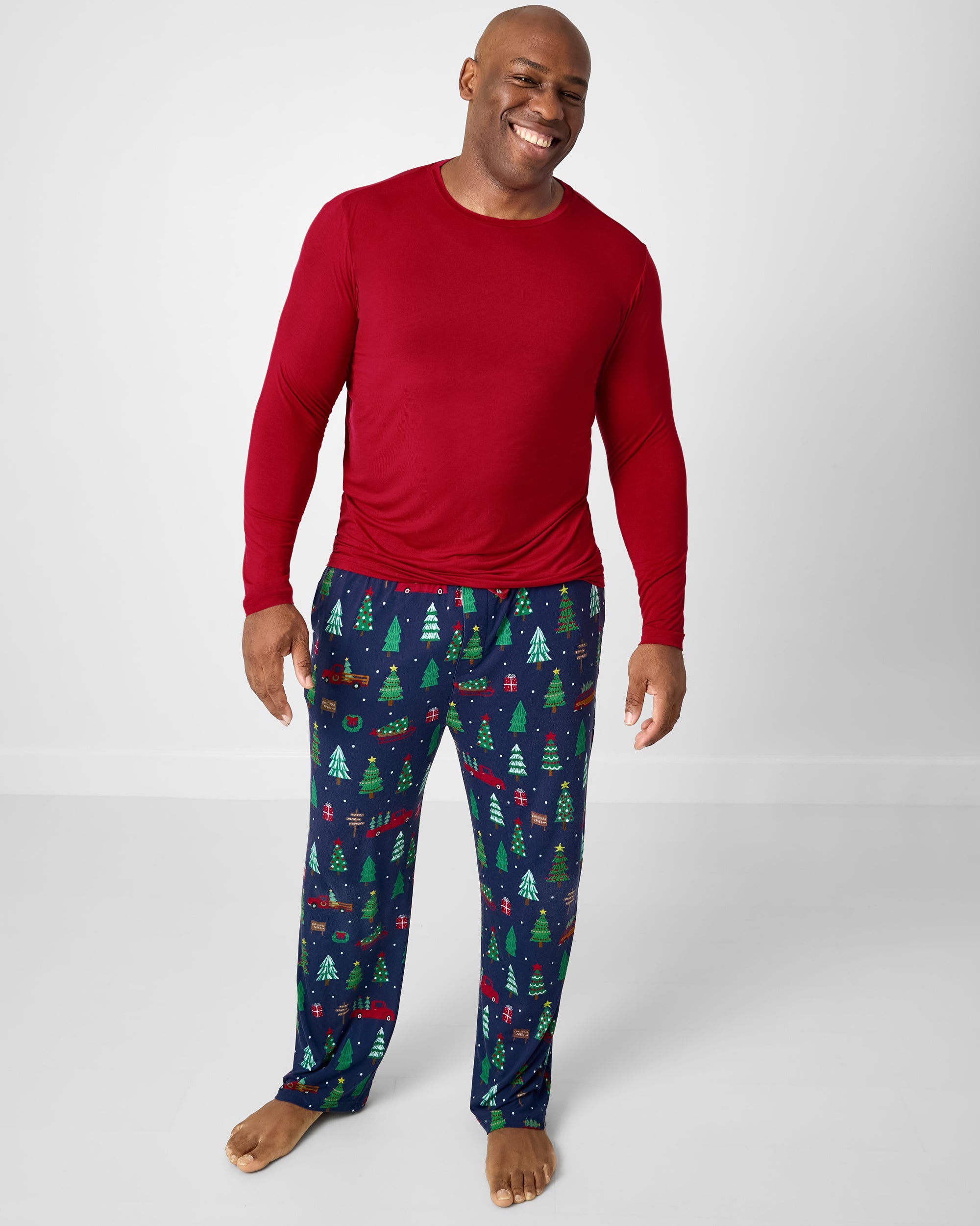 Man wearing the Holiday Red Men's Long Sleeve Pajama Top with Tree Traffic holiday print pajama pants