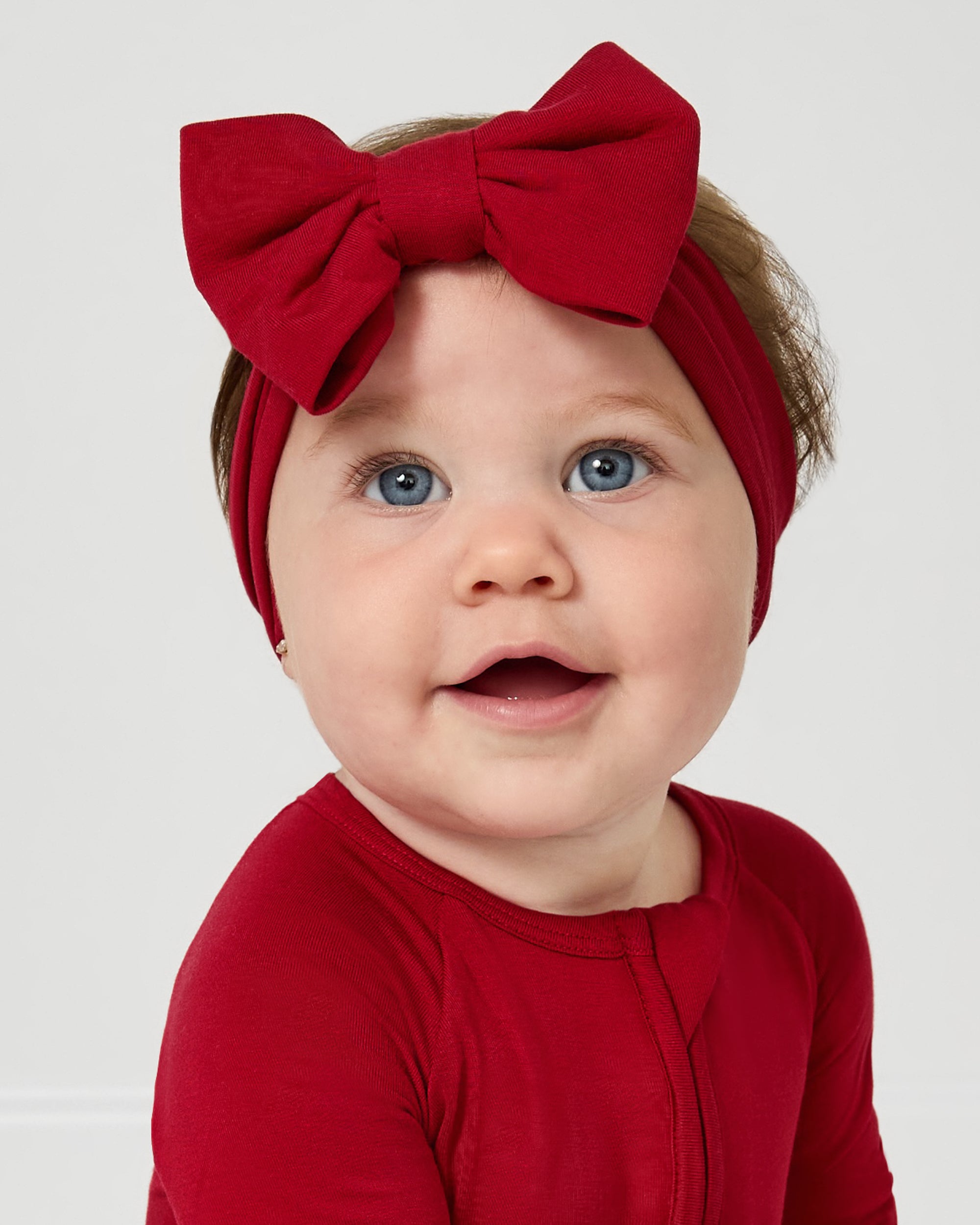 Baby wearing the Holiday Red Luxe Bow Headband