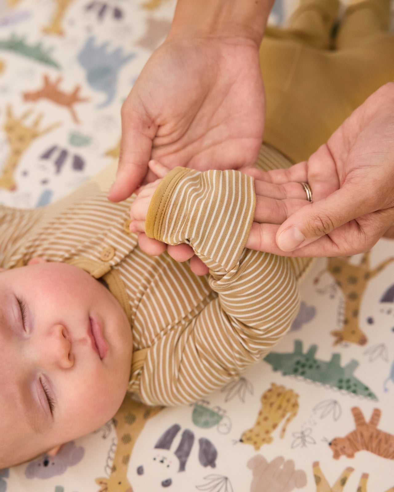 Adult adjusting the hand fold over feature on the Hazel Wood Stripe Henley Bodysuit