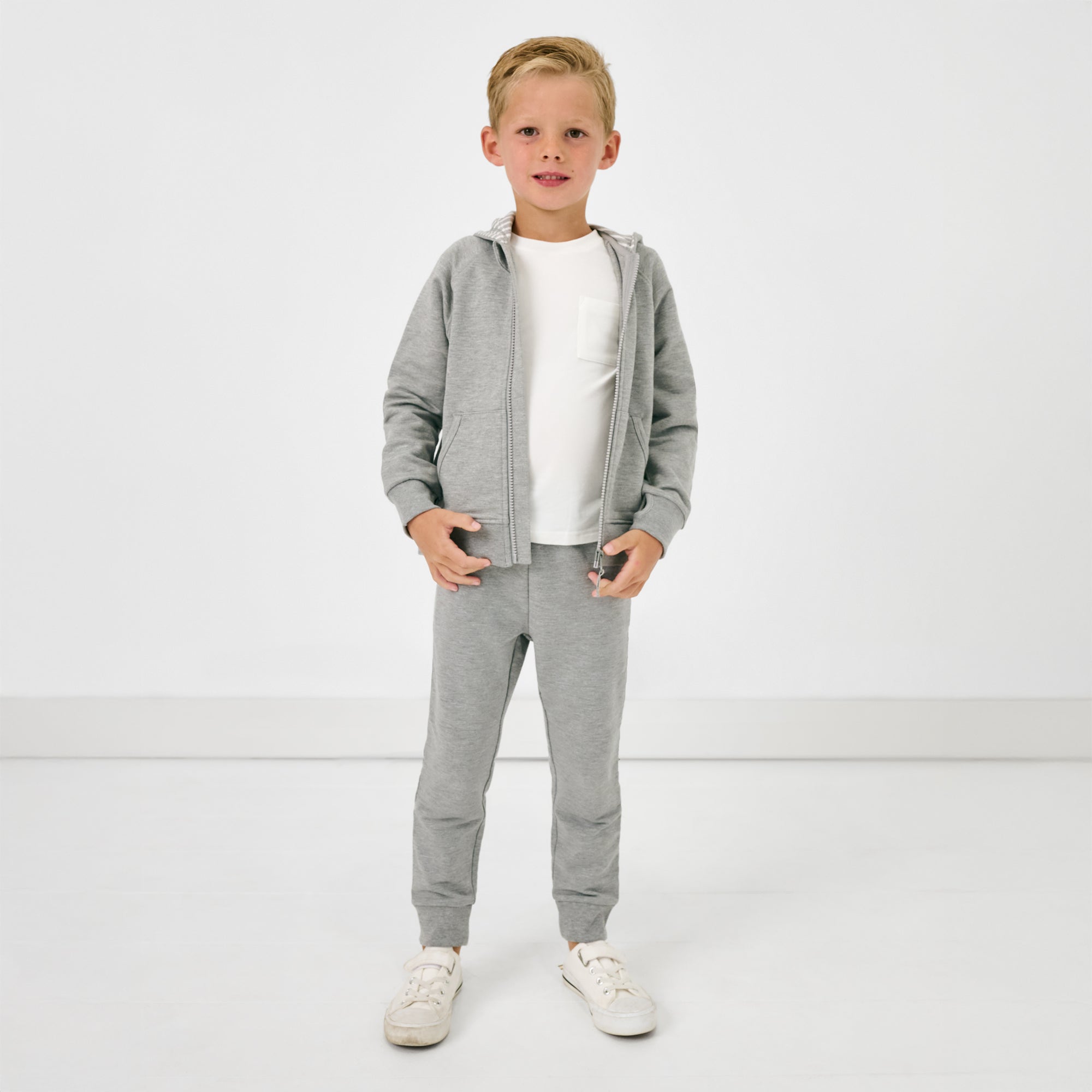 Standing child wearing the Heather Gray Jogger and matching zip up hoodie