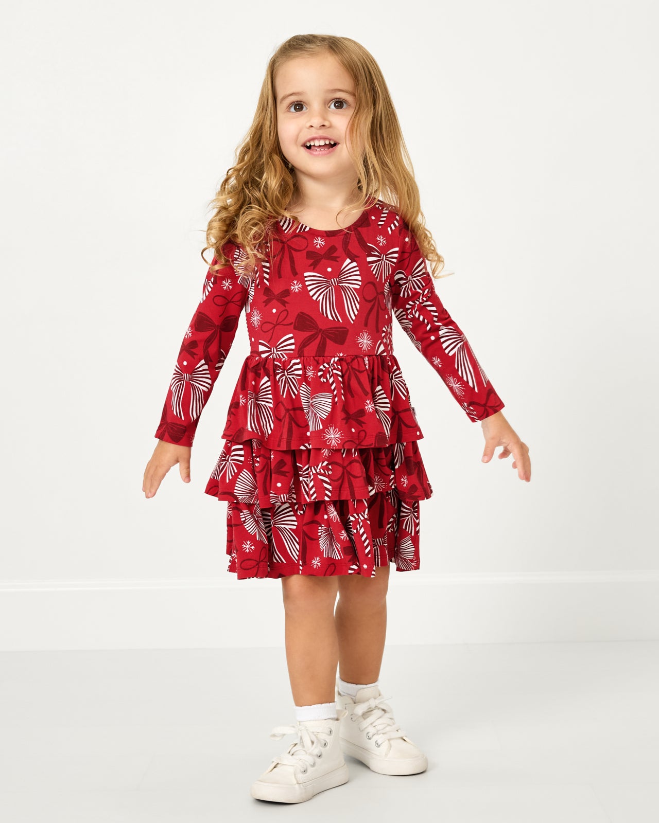 Standing girl wearing the Holiday Bows Tiered Dress