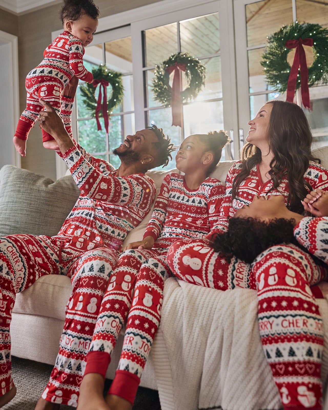 Family in a holiday themed room wearing Festive Fair Isle pajamas
