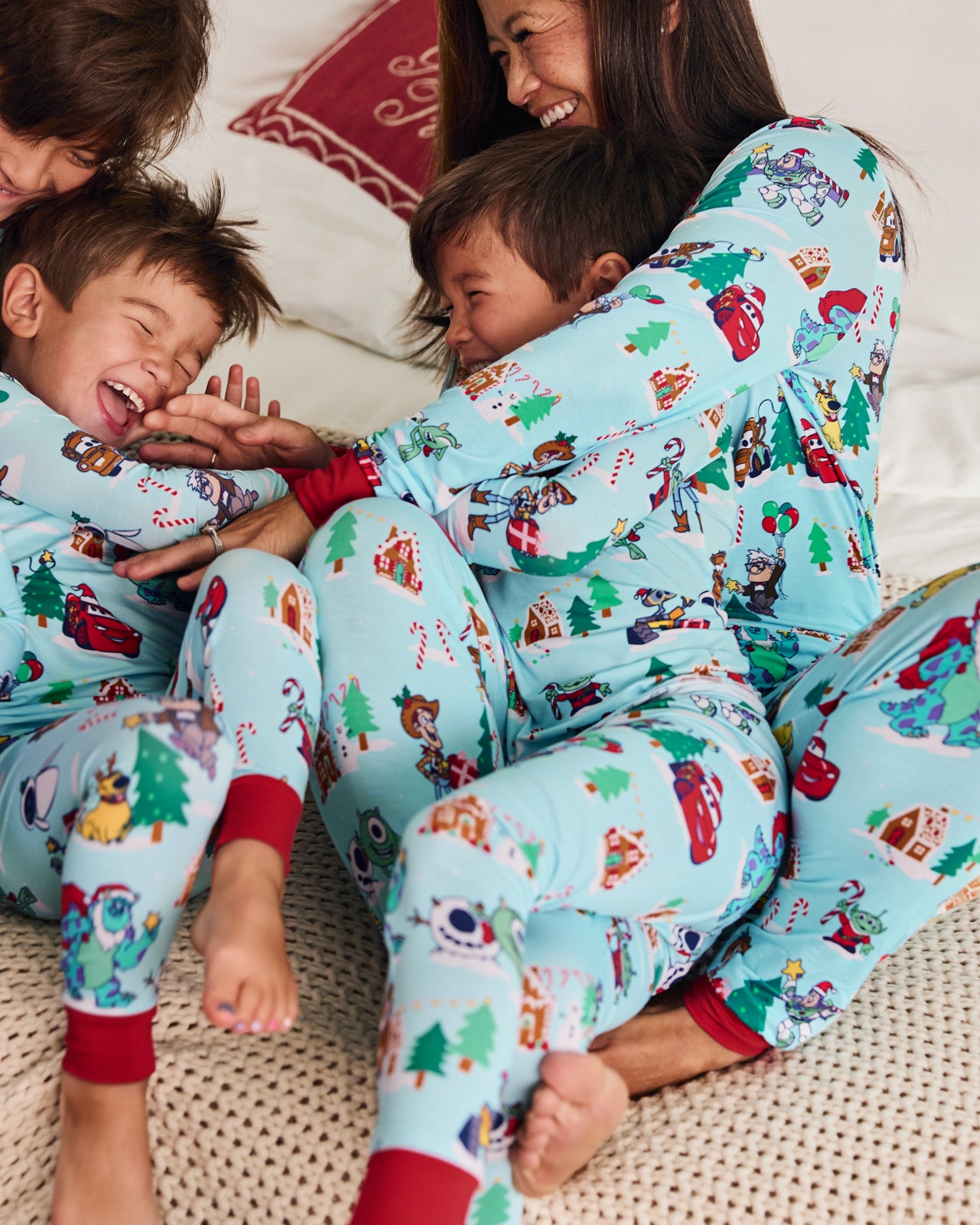 Mother and children wearing Disney & Pixar Christmas Village pajamas
