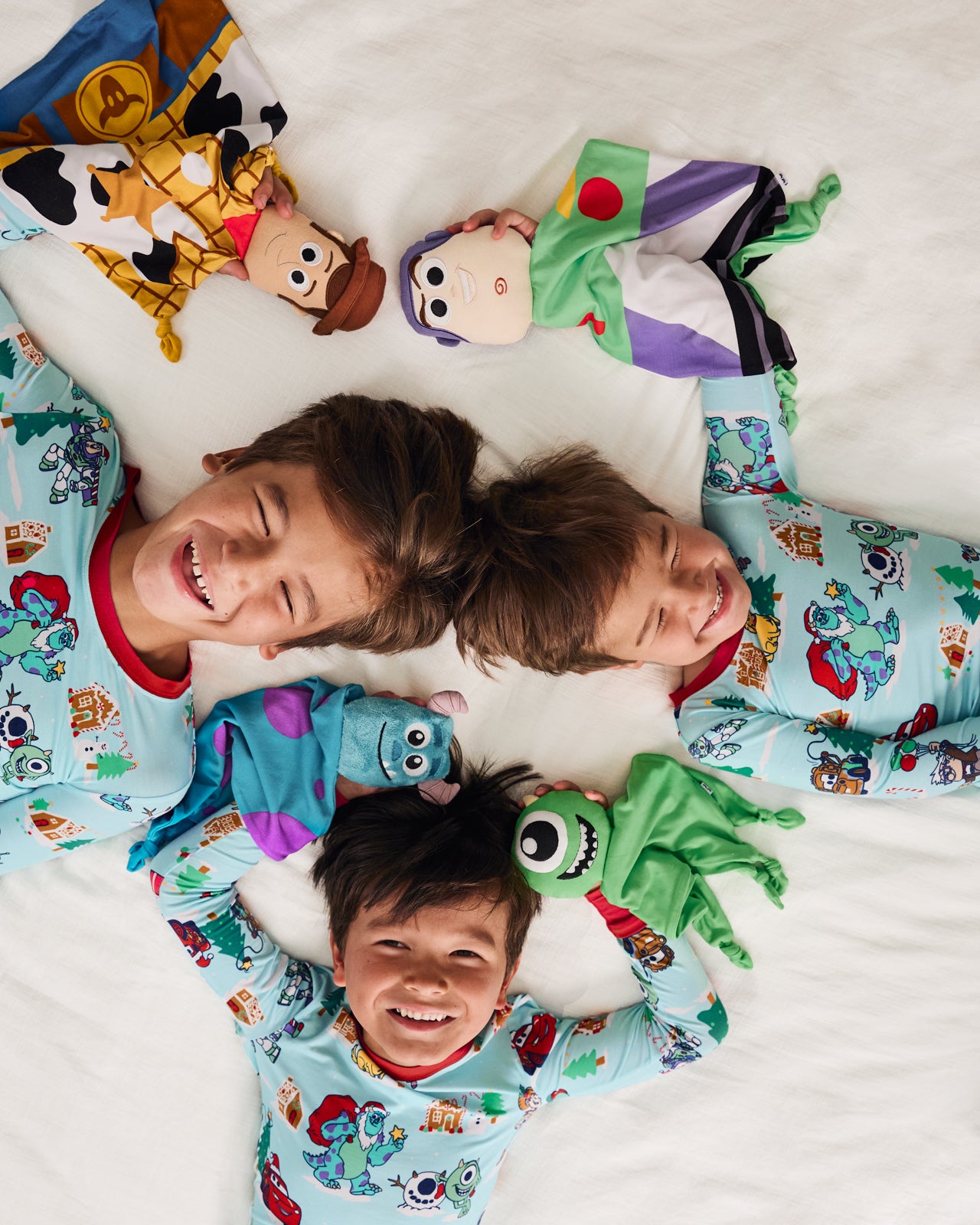 Children laying with various Disney & Pixar loveys