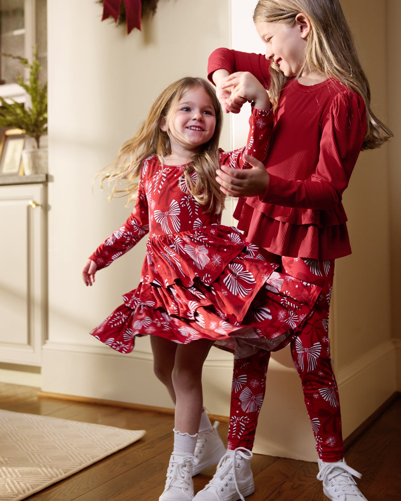 Two girls wearing matching Holiday Bows play styles