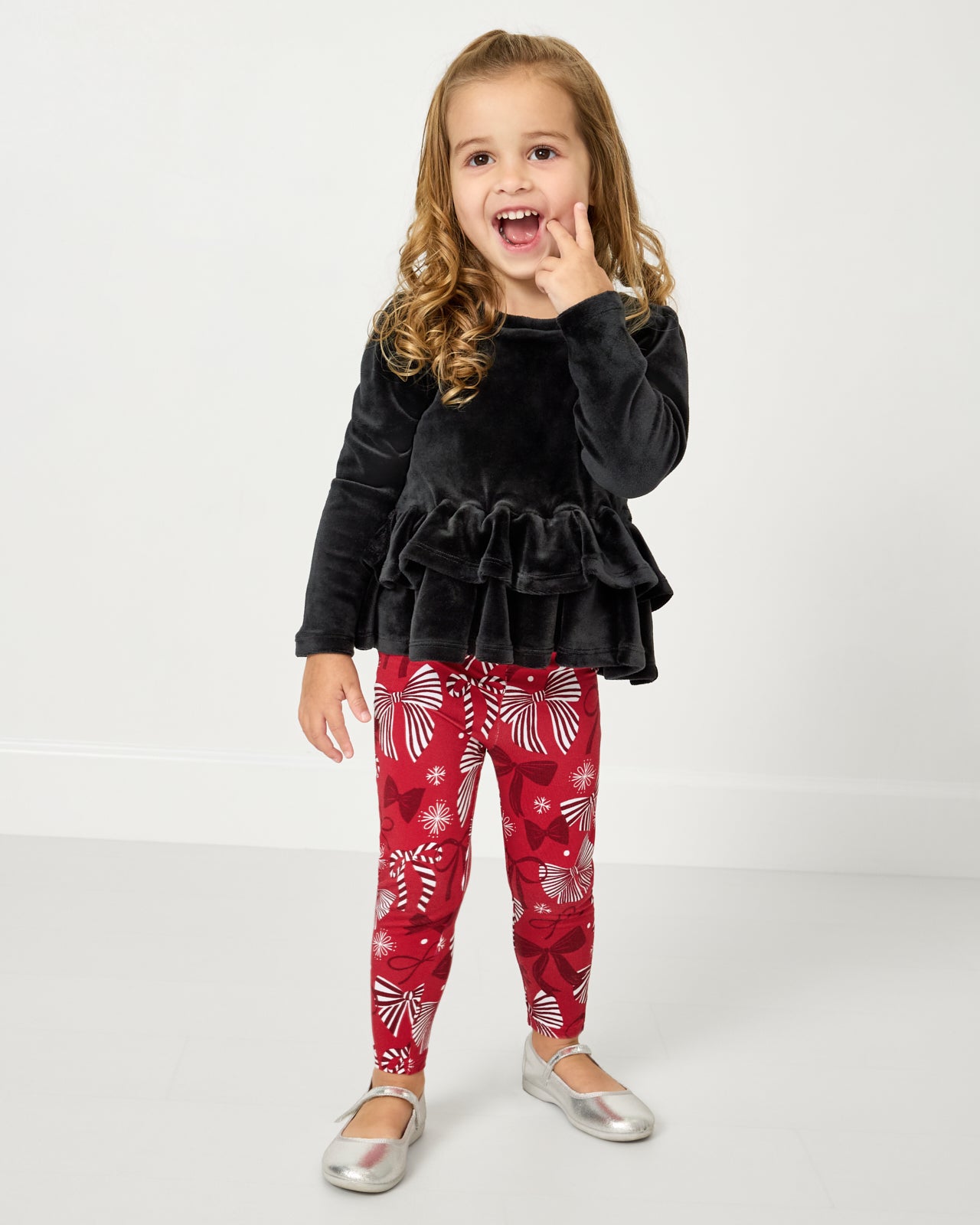 Girl wearing the Black Velvet Tiered Peplum Top with Holiday Bows leggings