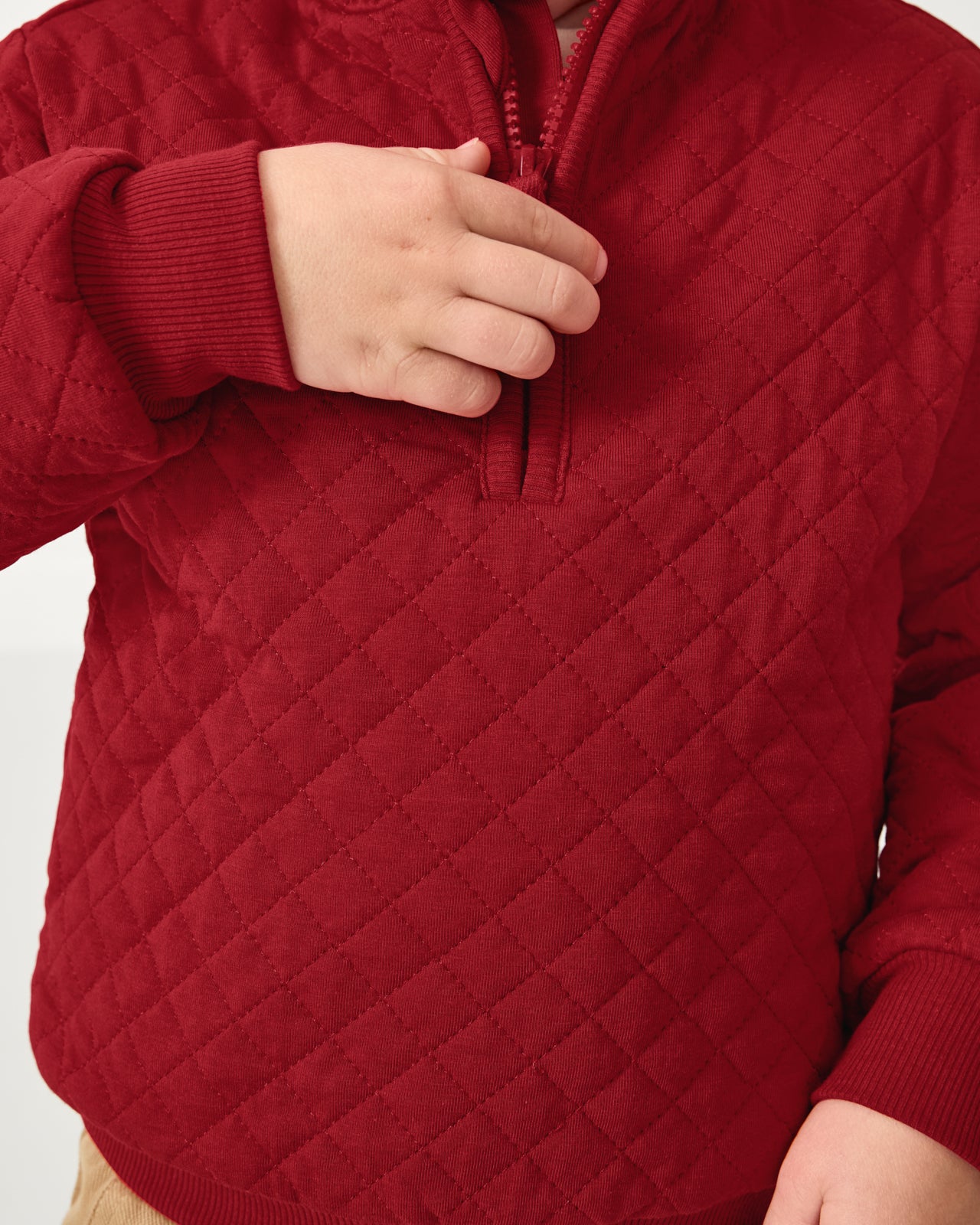 Close up of the zip detail on the Holiday Red Quilted Zip Pullover