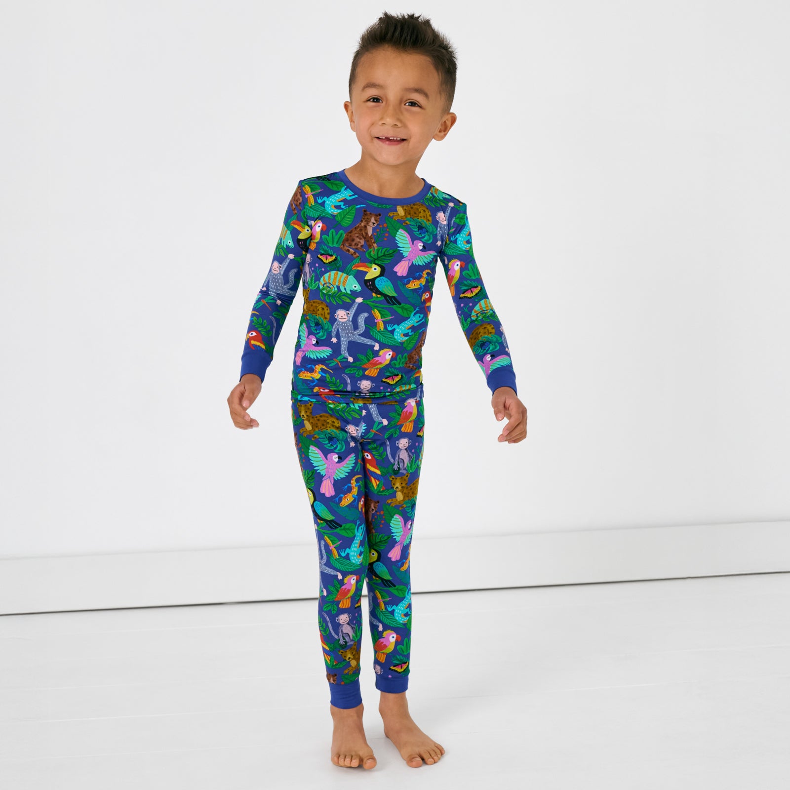 Standing child wearing the Treetop Tails Two-Piece Pajama Set