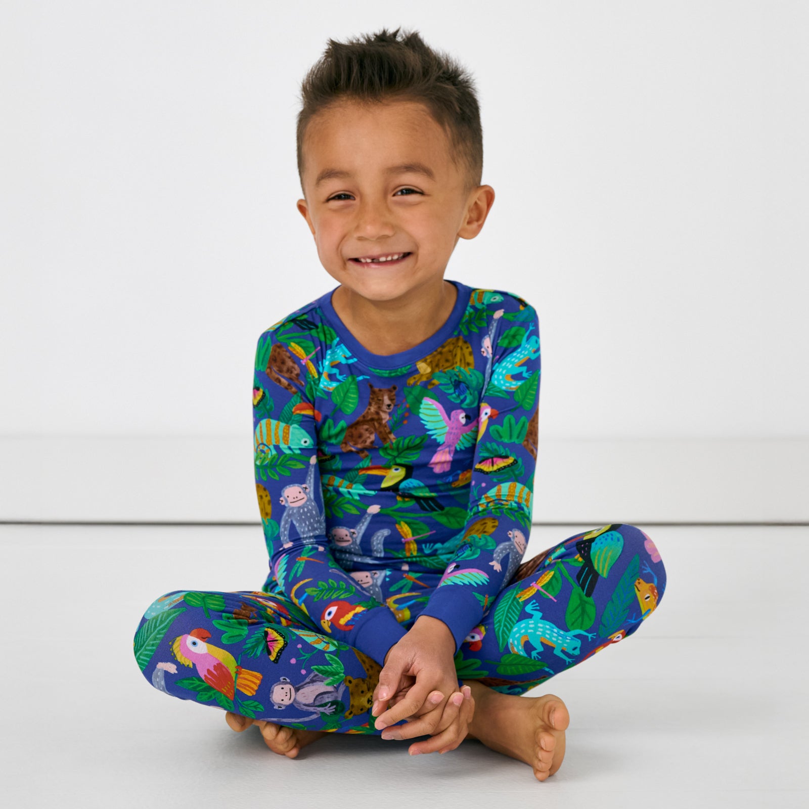 Sitting child wearing the Treetop Tails Two-Piece Pajama Set