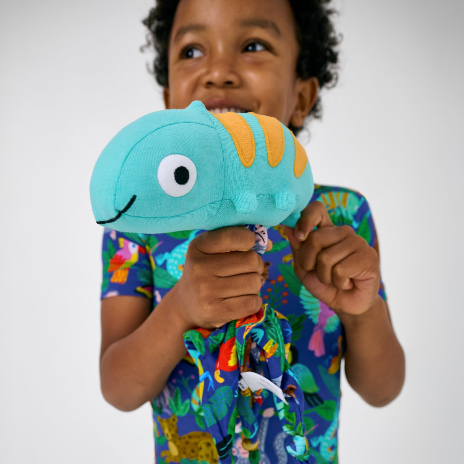 Alternate of child holding up the Cammie the Chameleon Sleepyhead Lovey