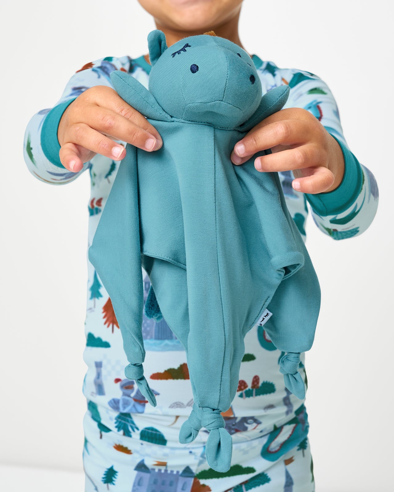 Child holding up the Spark the Dragon Sleepyhead Lovey