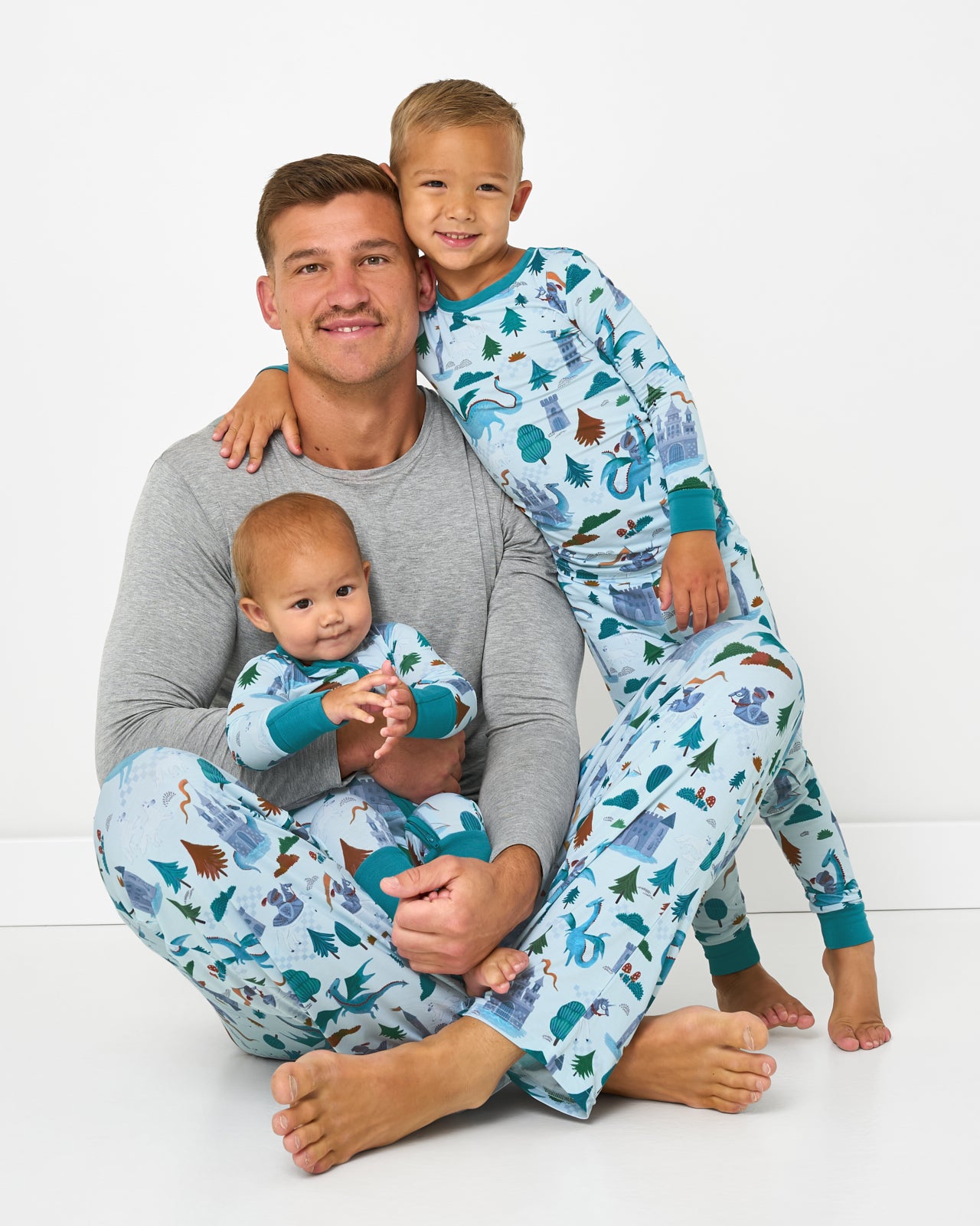 Father and two children wearing matching Knight's Quest bamboo pajamas