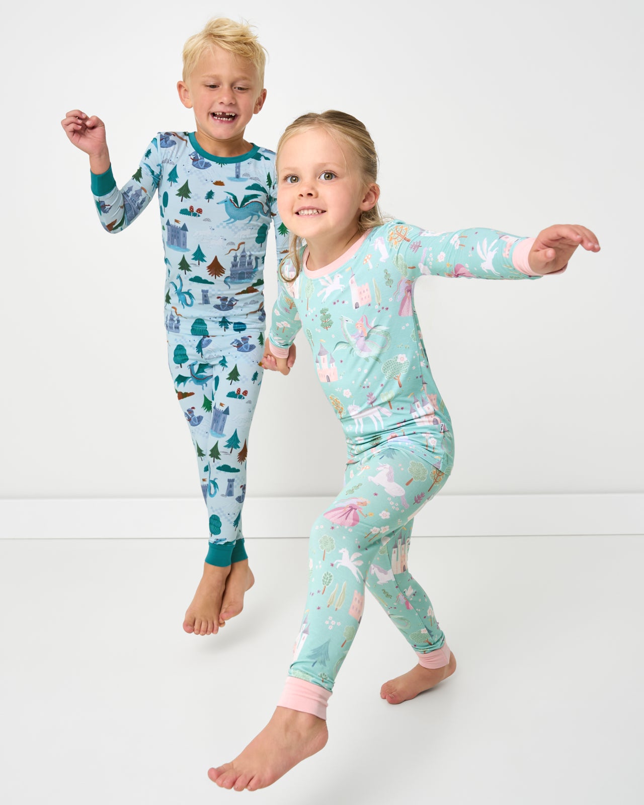Two children in motion wearing Knight's Quest and Enchanted Fairytale Two-Piece Pajama Sets