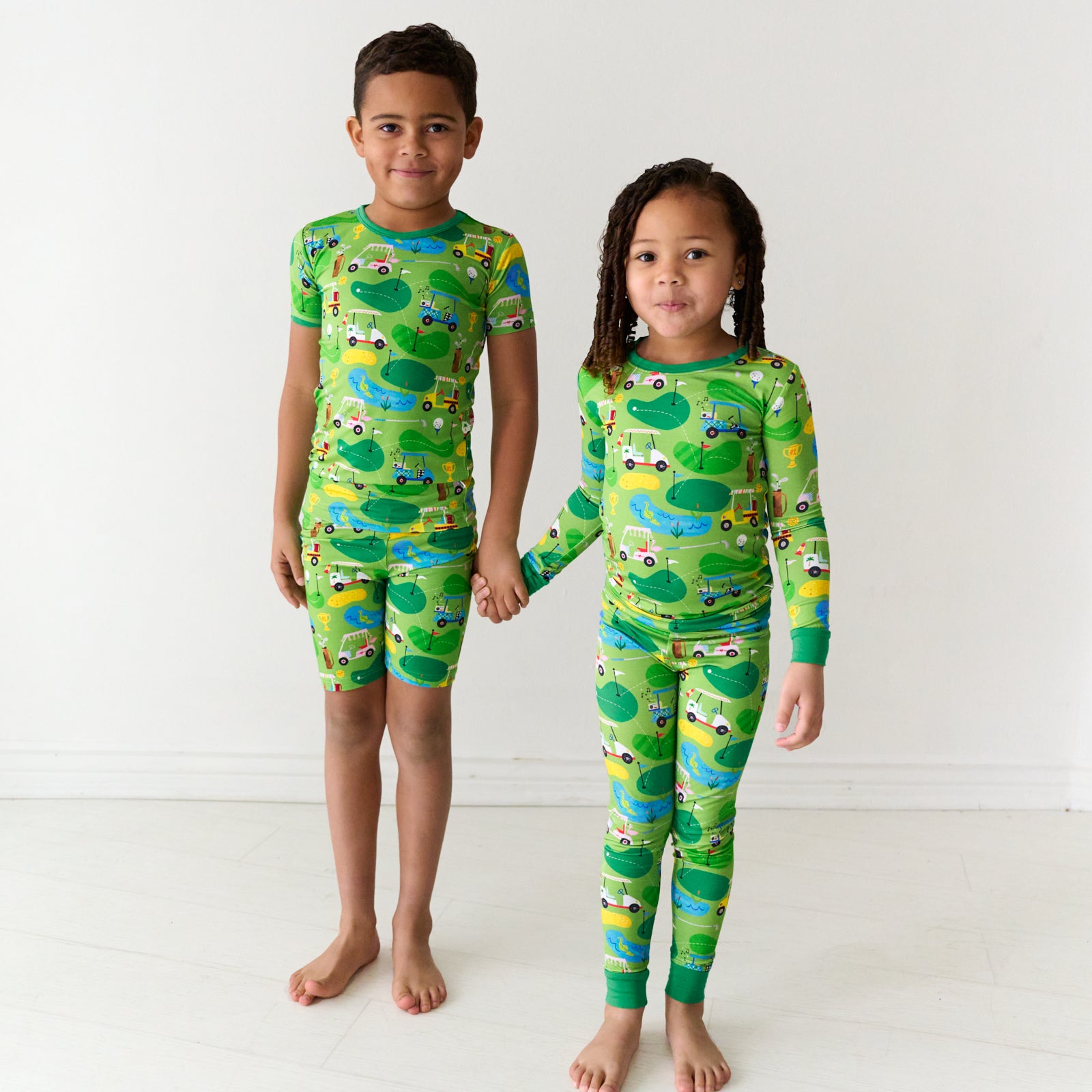 Two children holding hands wearing matching Fairway Fun pajamas