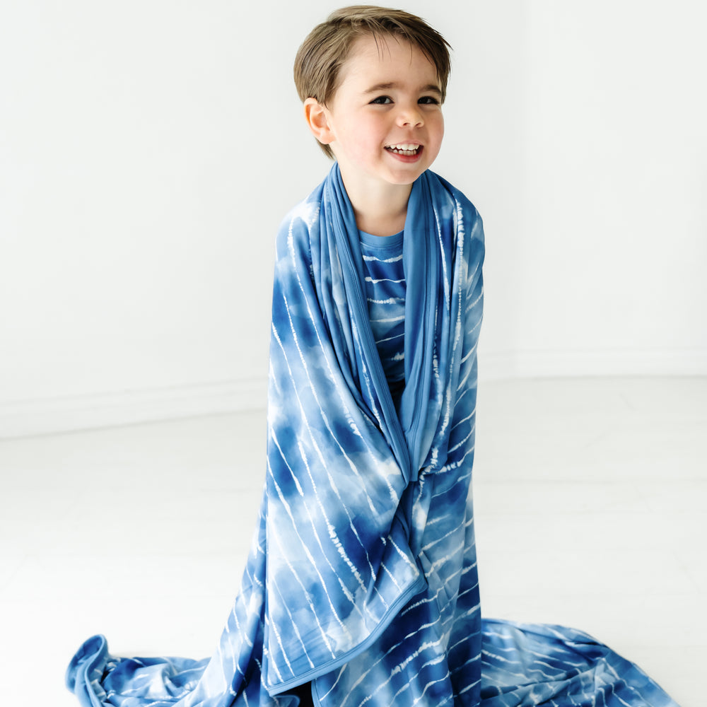Child wrapped up in a Blue Tie Dye Dreams large cloud blanket
