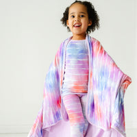 Child wrapped up in a Pastel Tie Dye Dreams large cloud blanket wearing matching pajamas